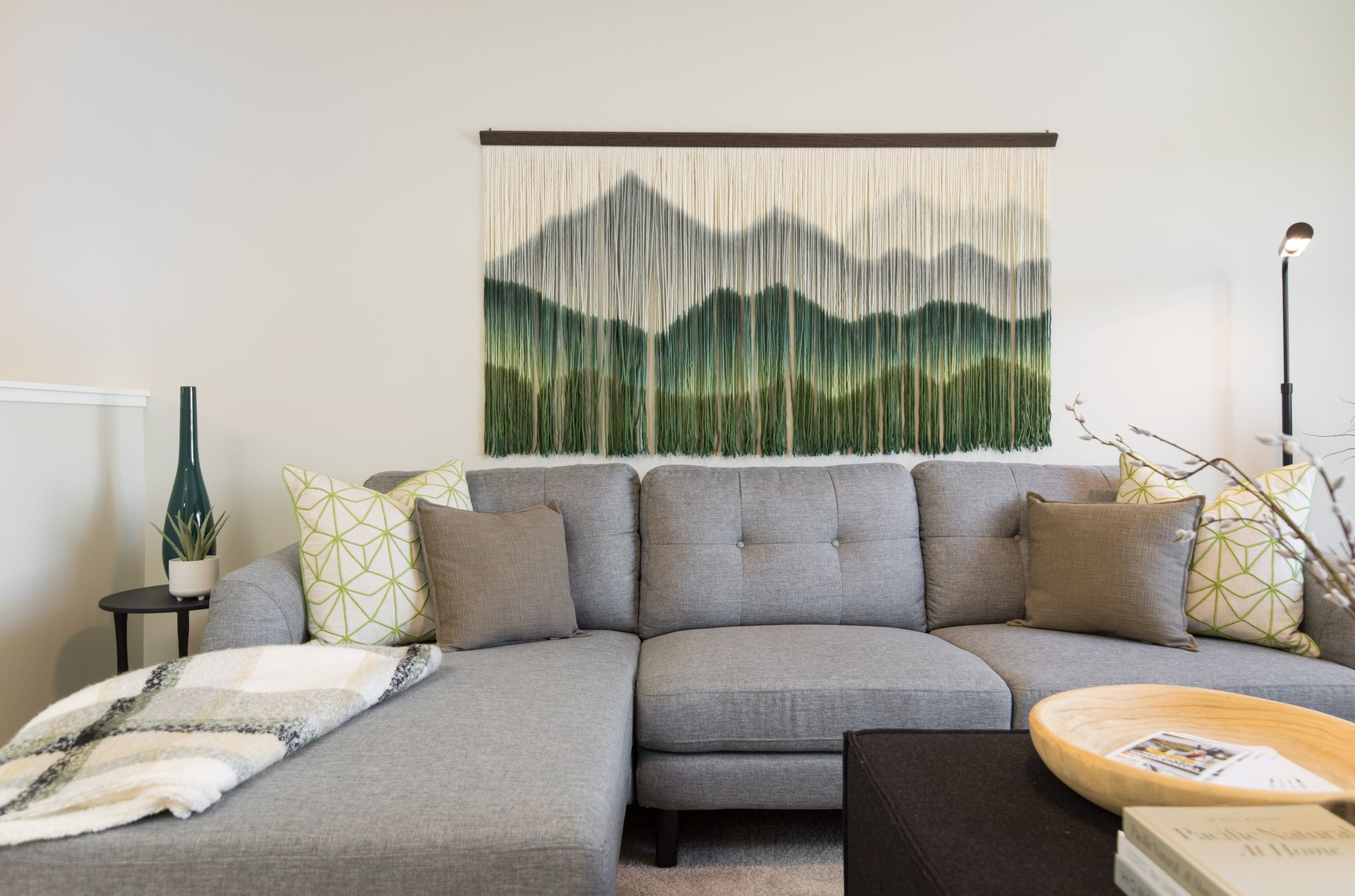 A living room with a couch and a painting on the wall.