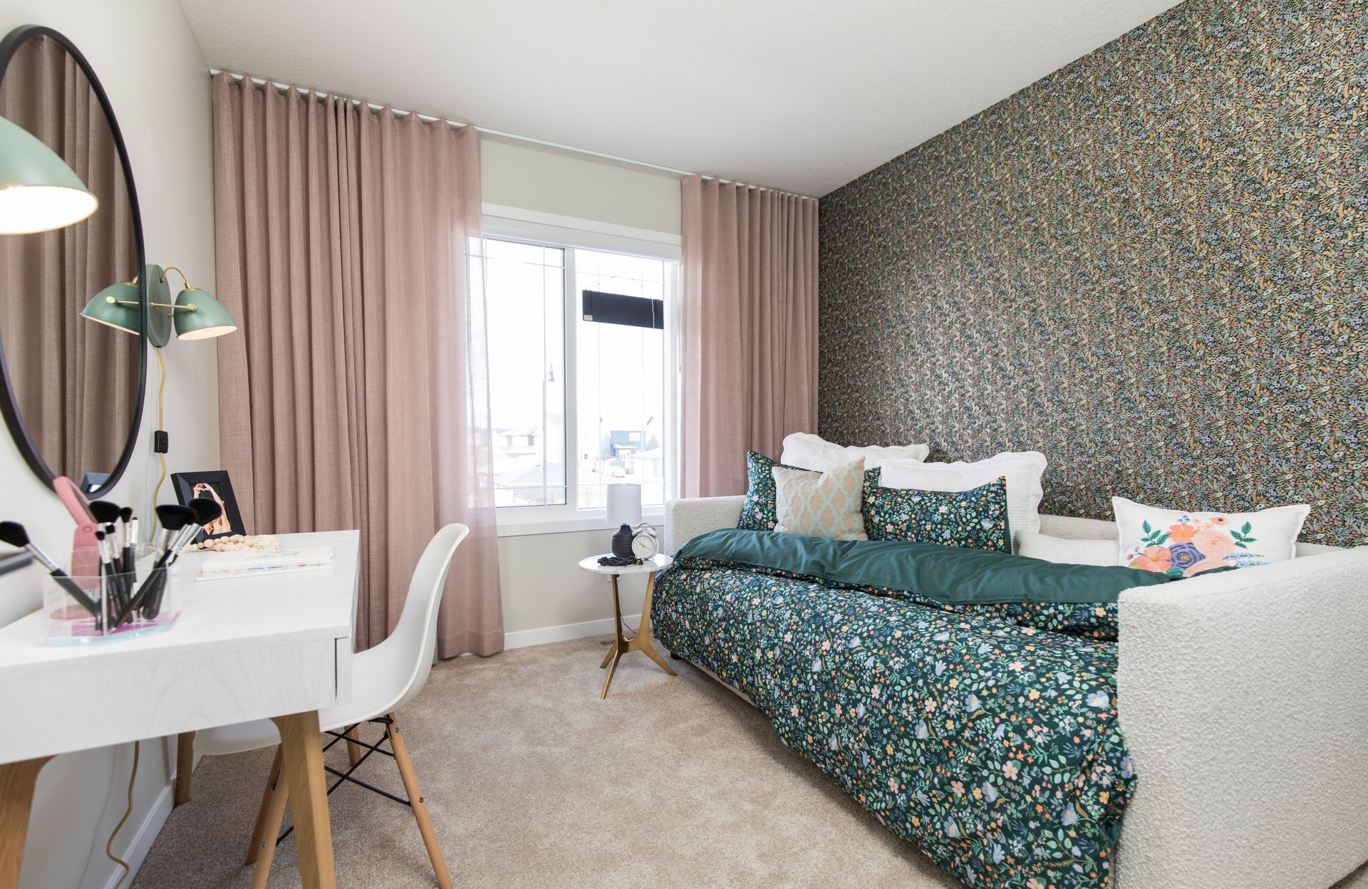 A bedroom with a day bed , desk , chair and mirror.