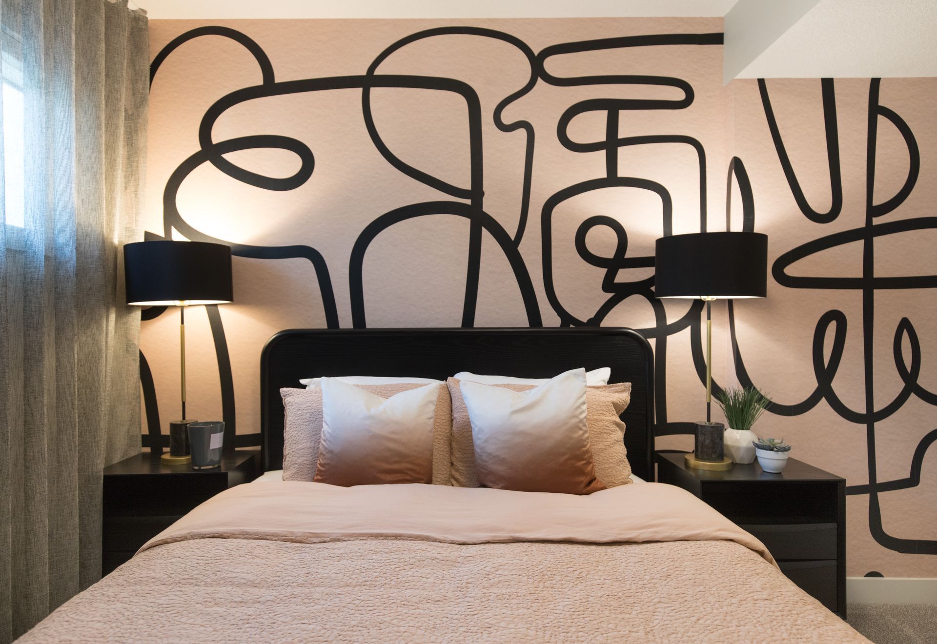 A bedroom with a bed , nightstands , lamps and a mural on the wall.