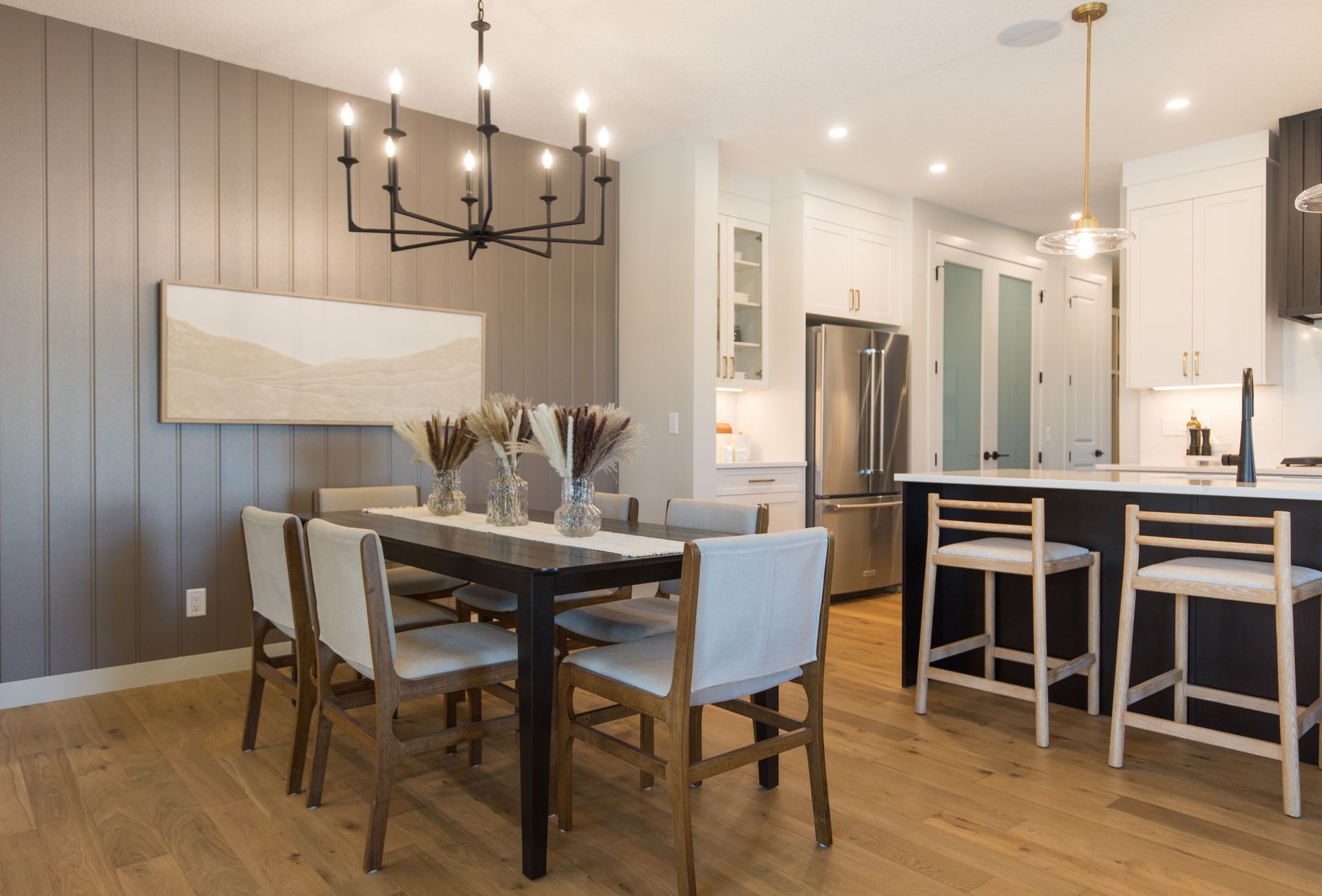 A dining room table and chairs in a kitchen with a chandelier hanging from the ceiling.