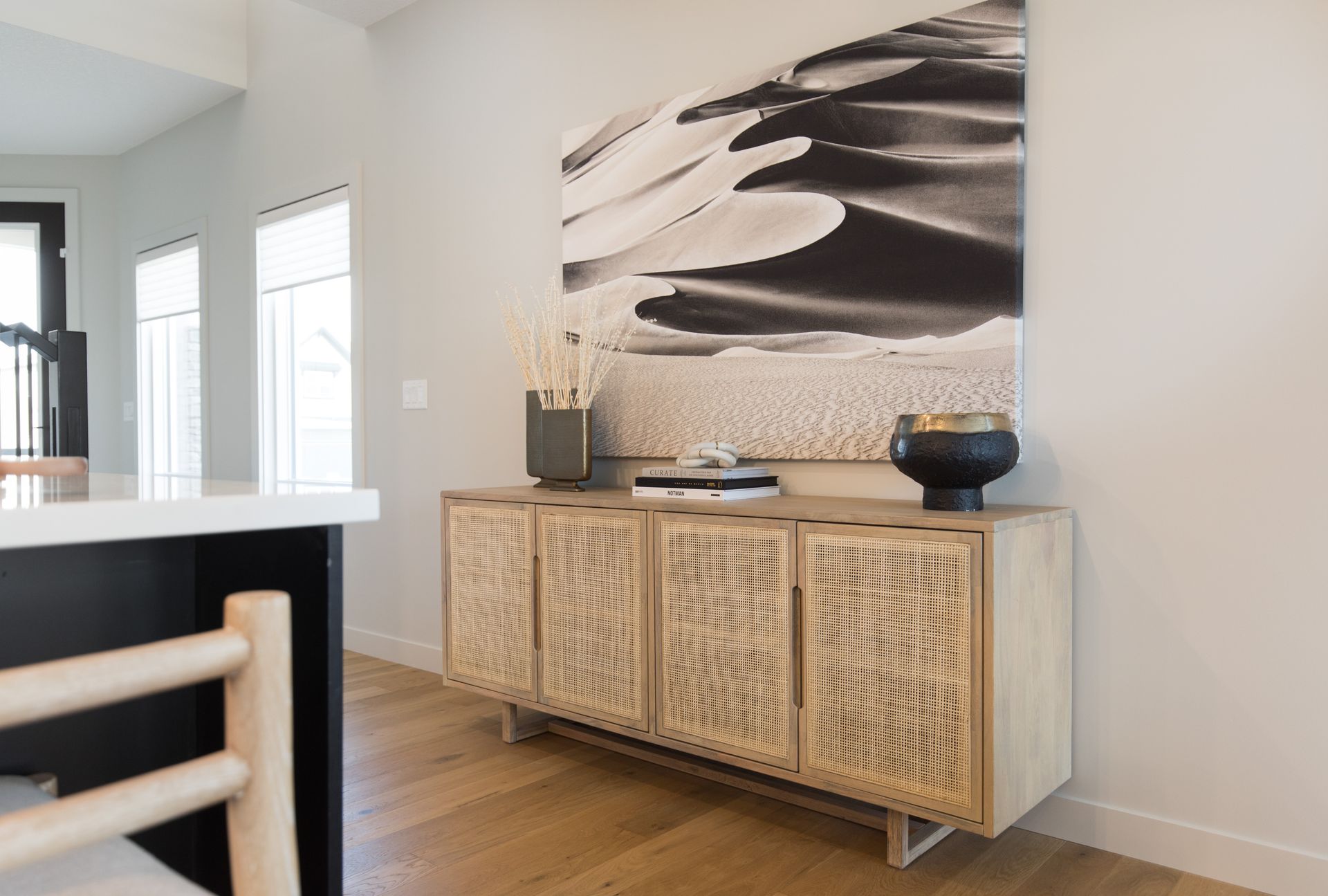 There is a large painting on the wall above the dresser.