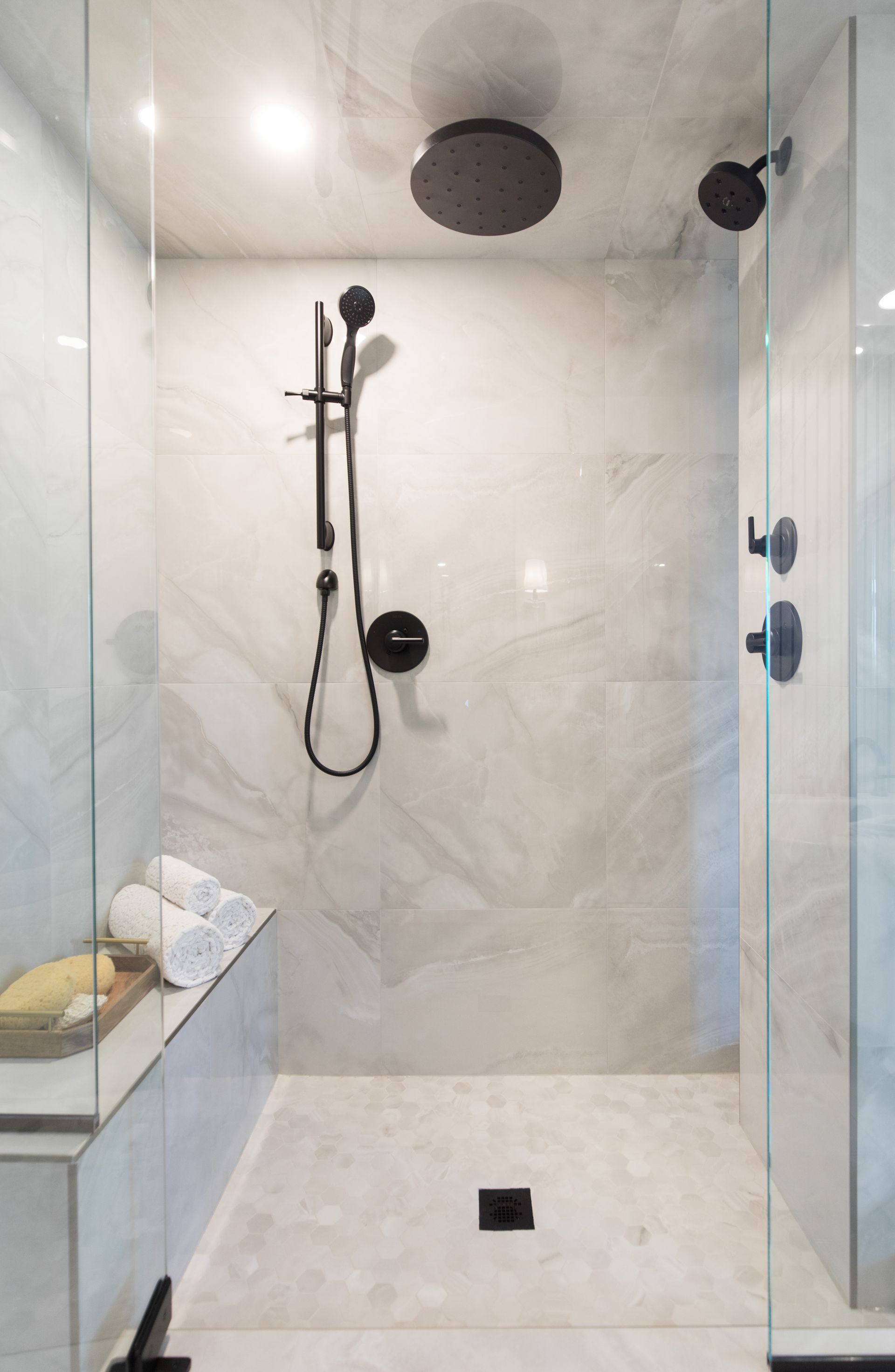 A bathroom with a walk in shower and two shower heads.