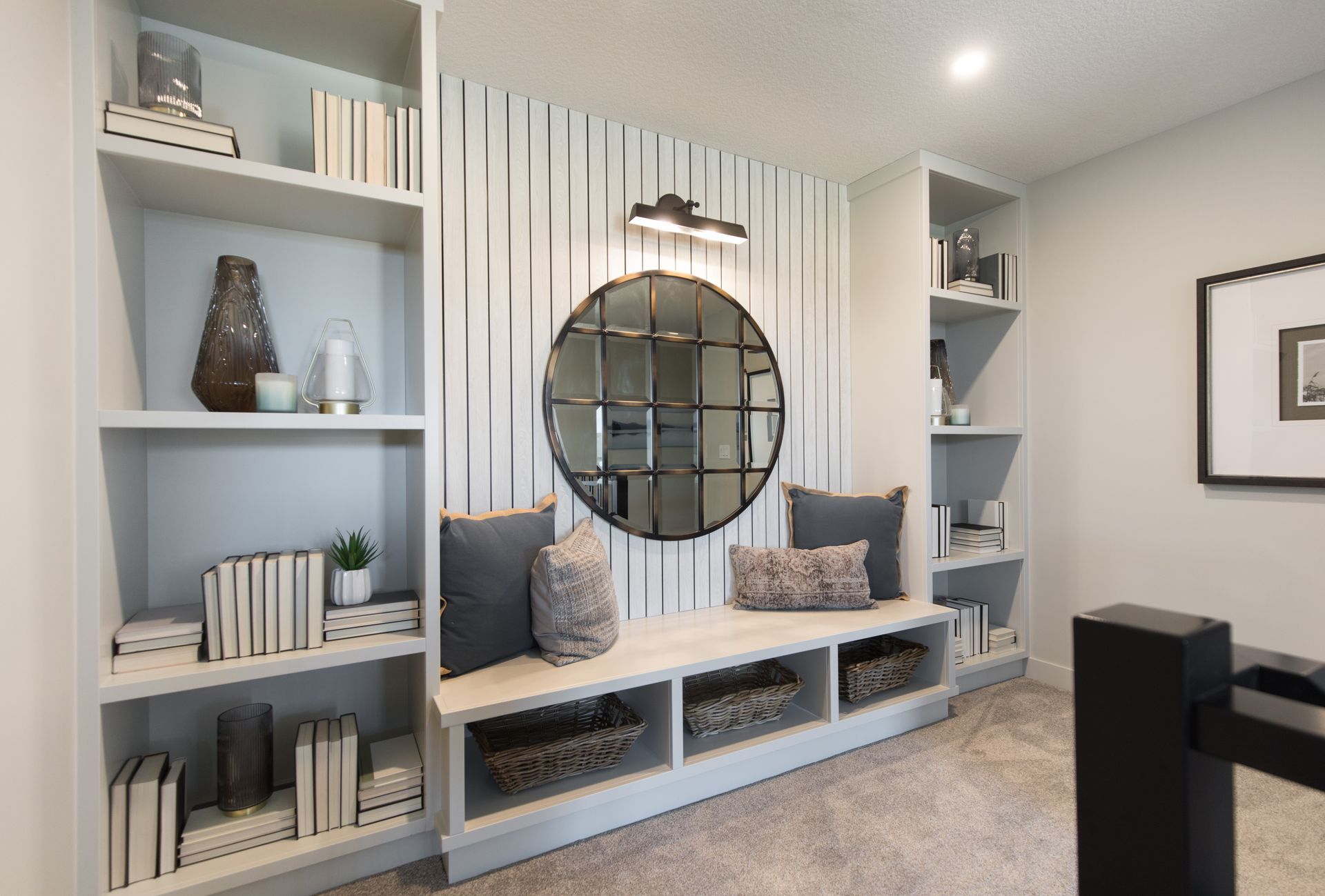 A living room with a bench and a mirror on the wall.