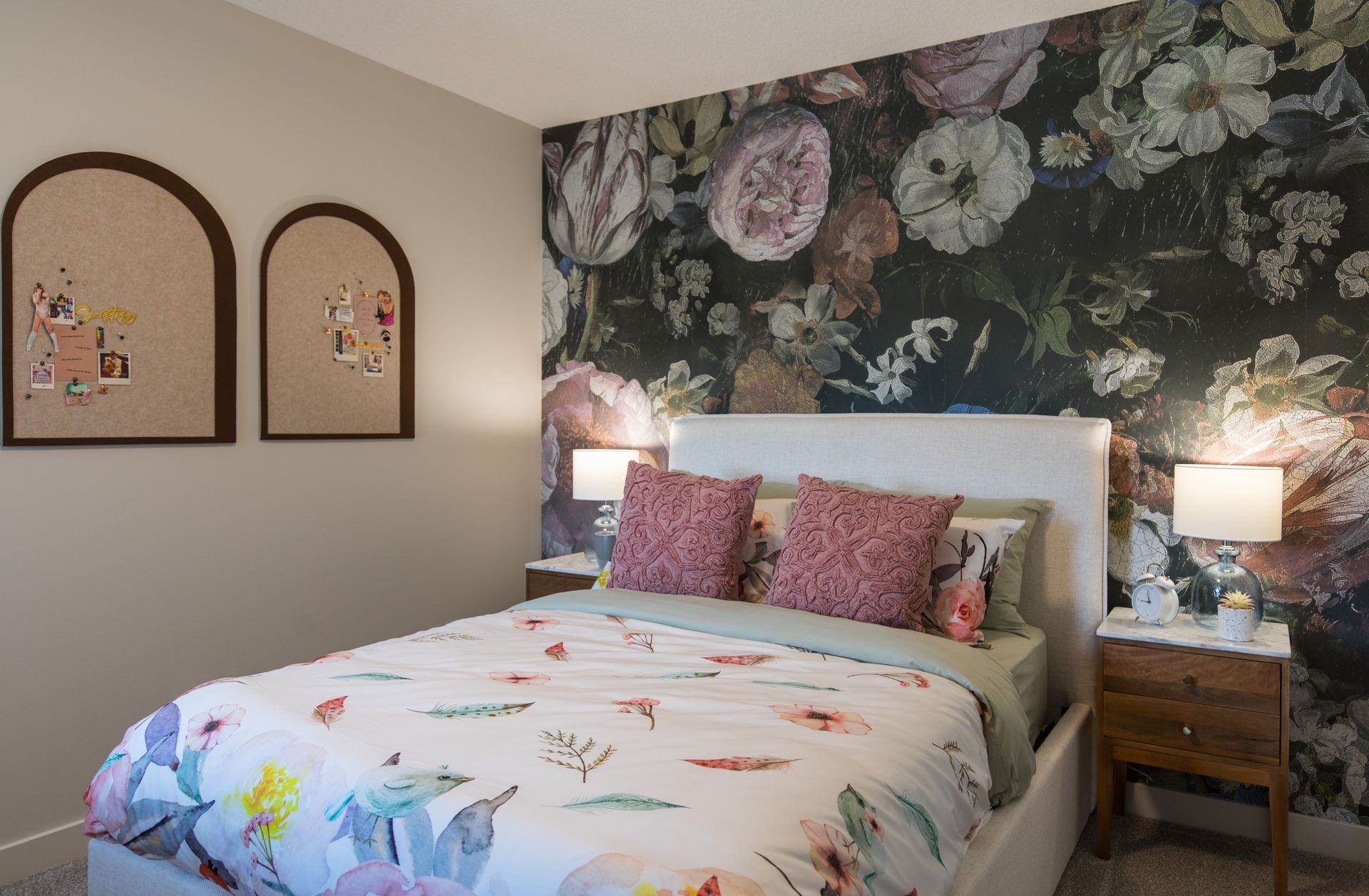 A bedroom with a bed and a floral wallpaper on the wall.