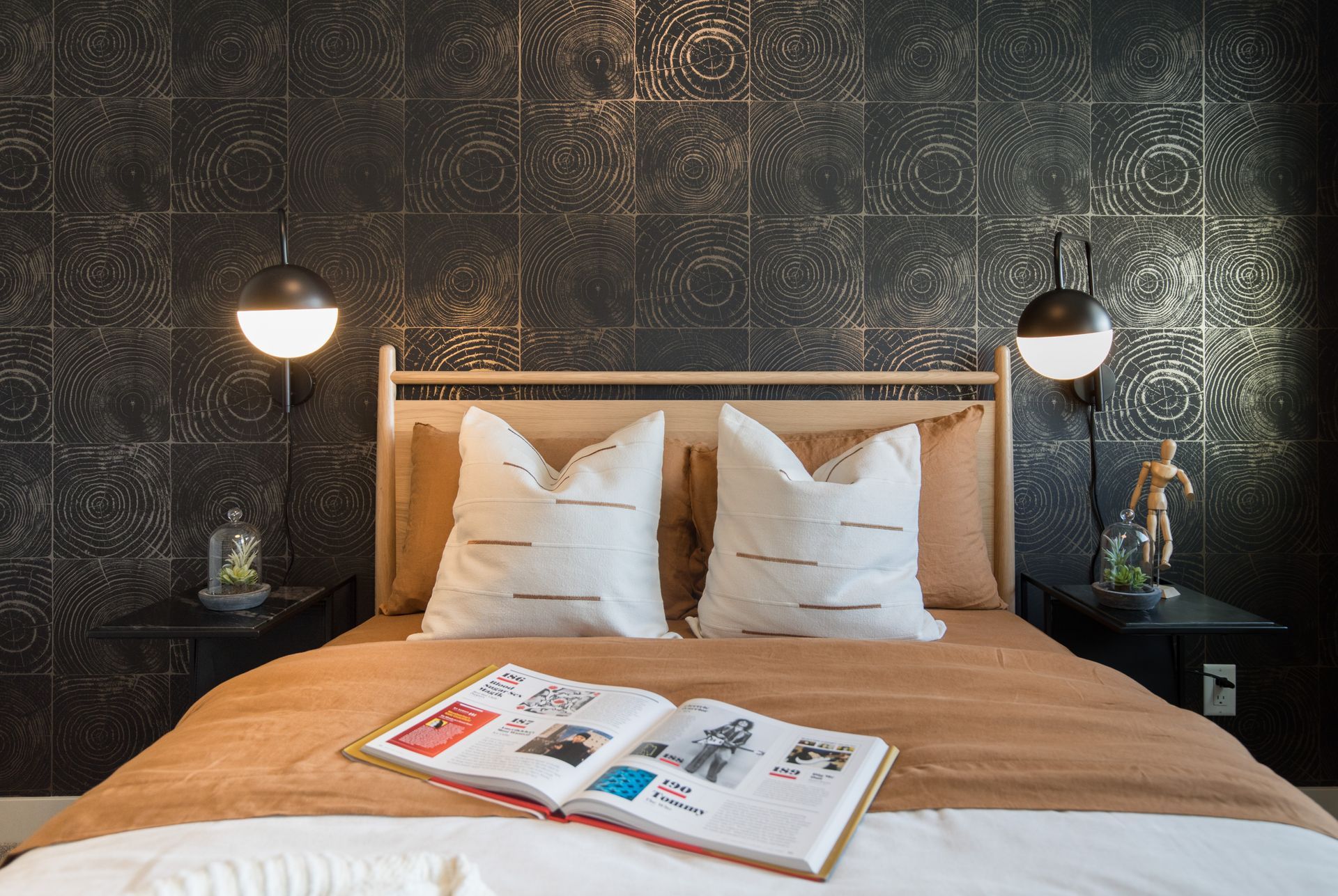 A bed with two pillows and a book on it.