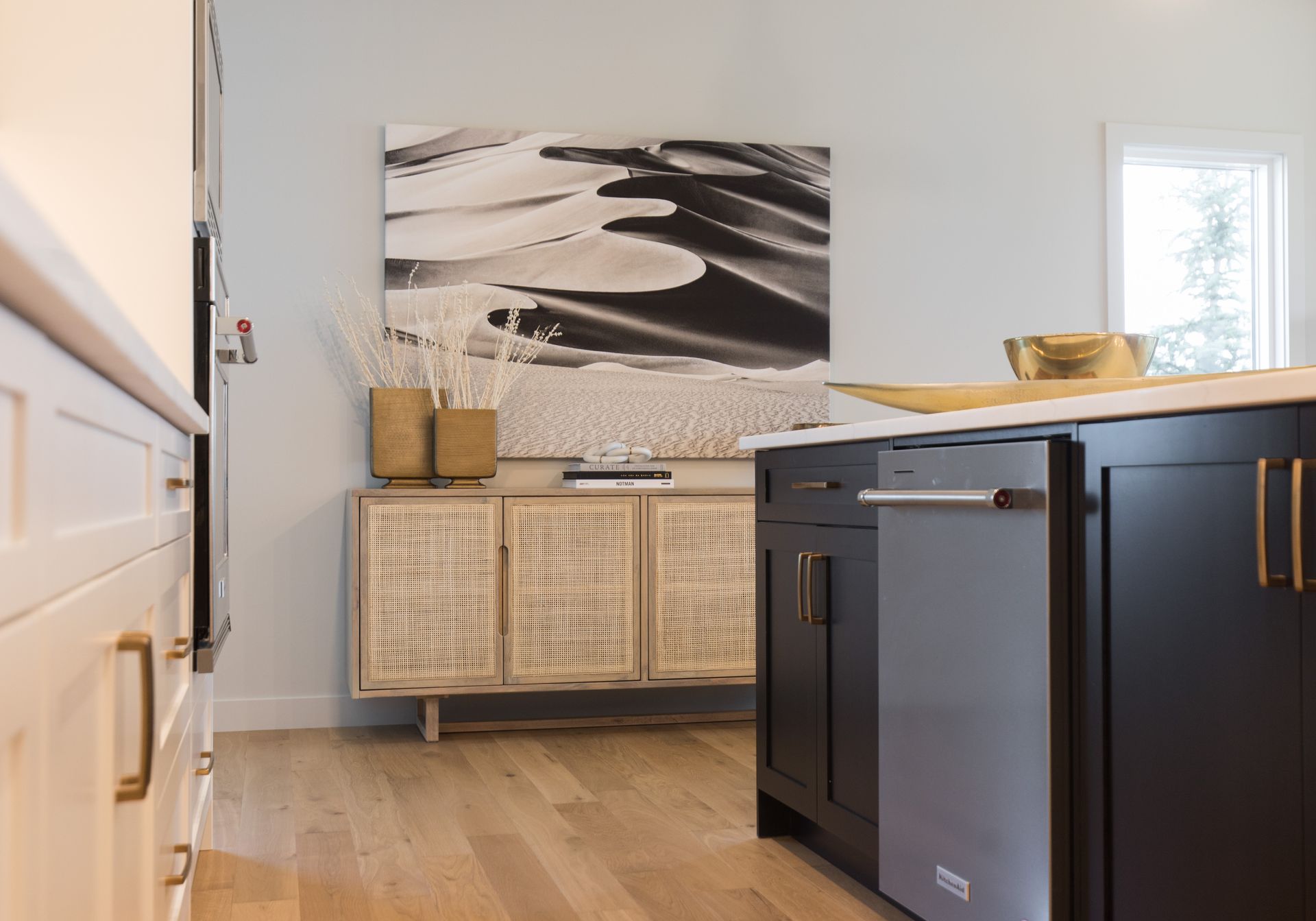 A kitchen with black cabinets and a stainless steel dishwasher.