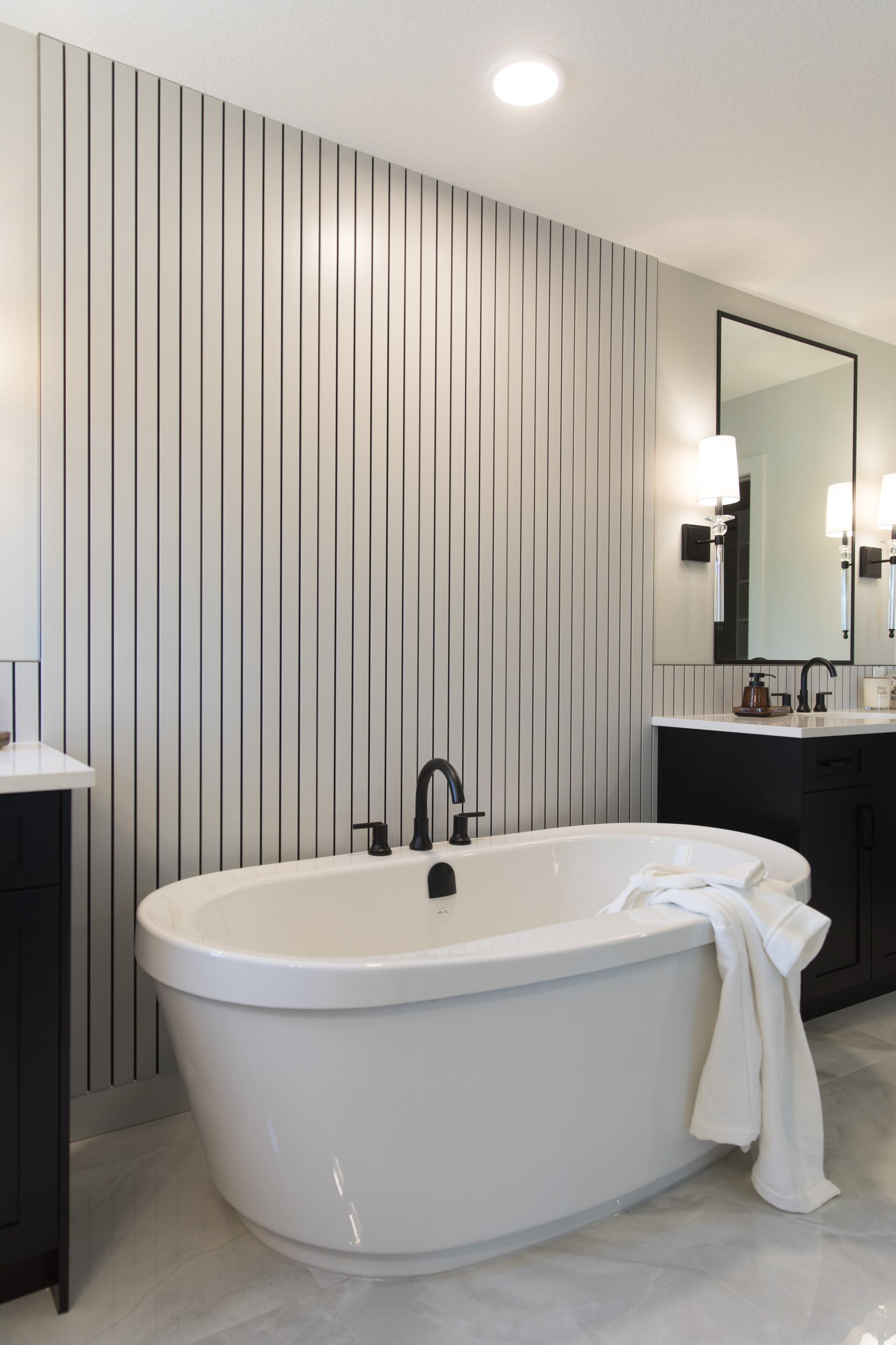 A bathroom with a bathtub , sink and mirror.