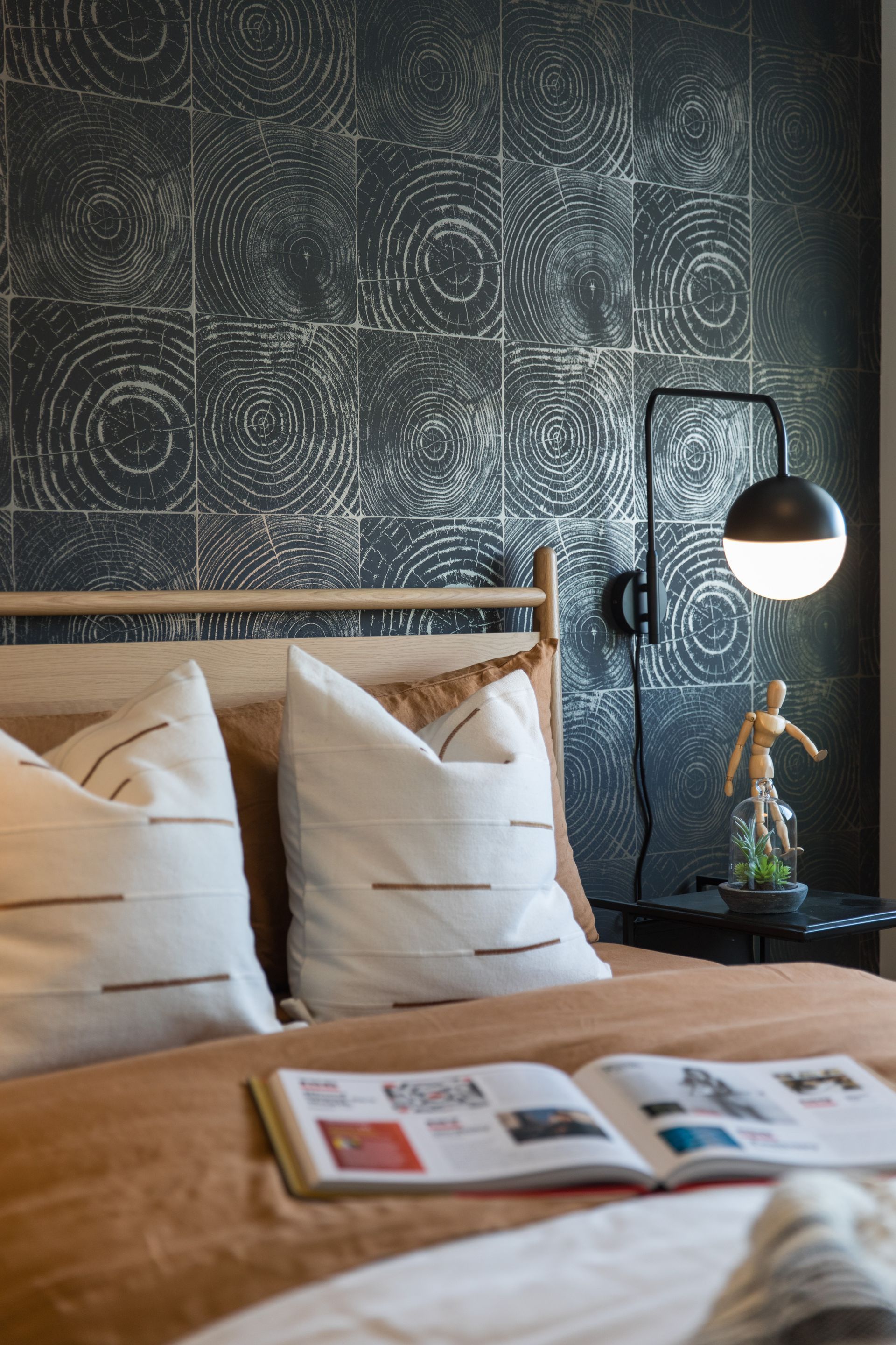 A bedroom with a bed , pillows , a lamp and a book on the bed.