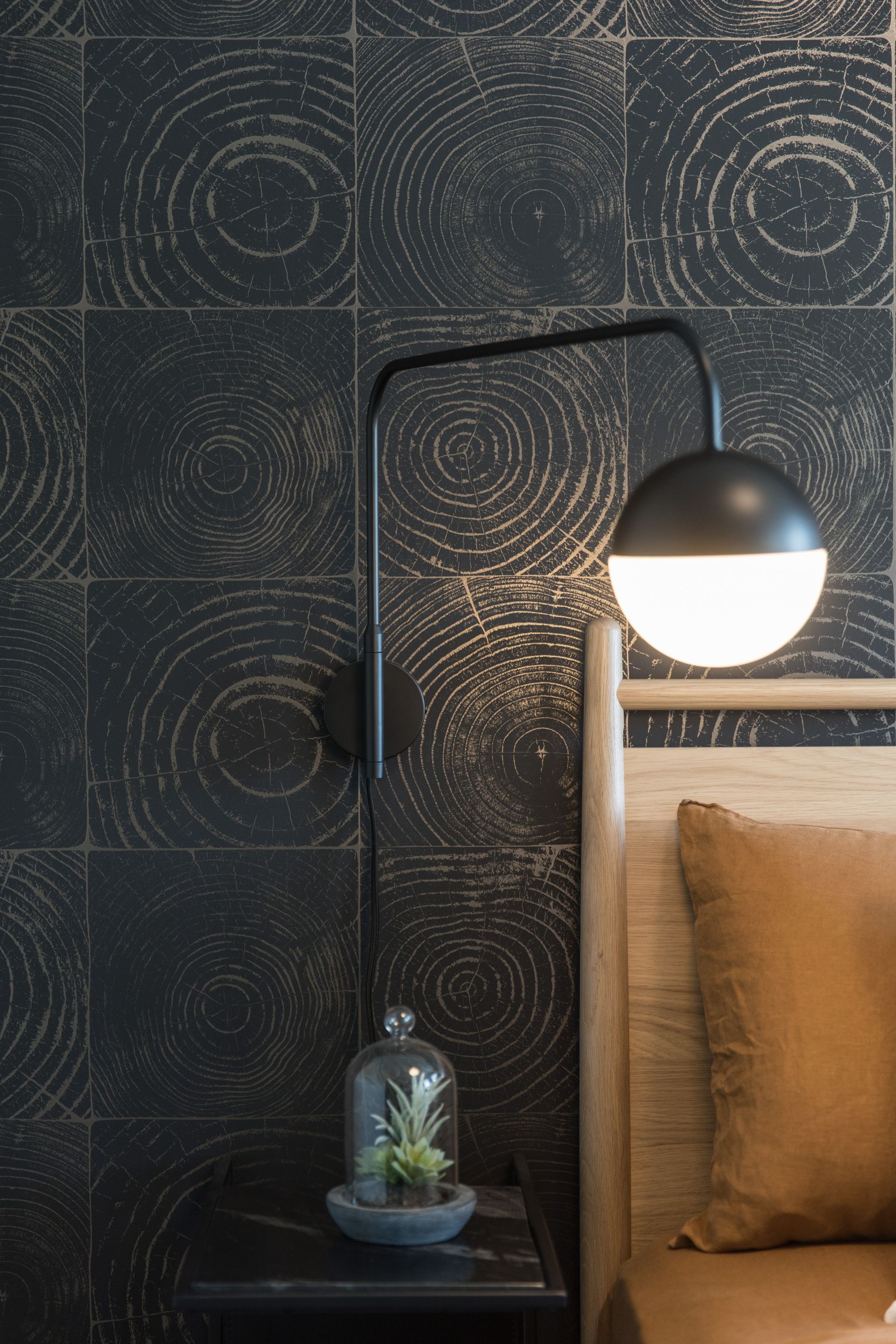 There is a lamp on the wall next to the bed.