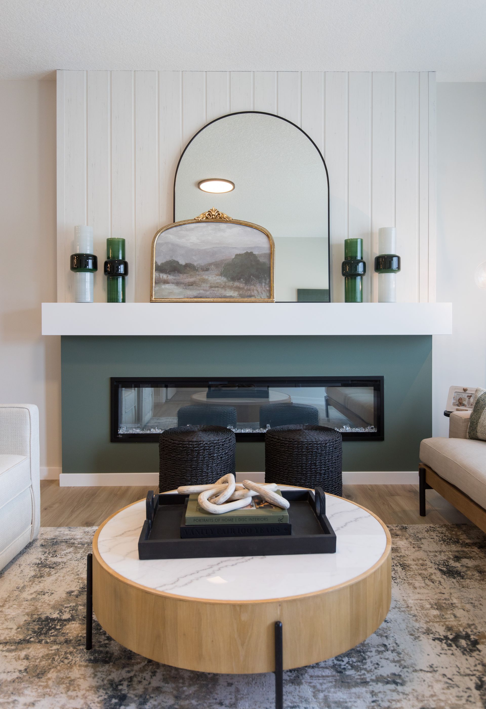 A living room with a fireplace and a round coffee table