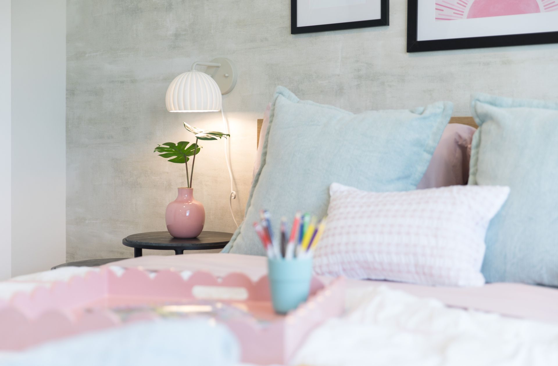 A bed with pillows and a vase of flowers on it