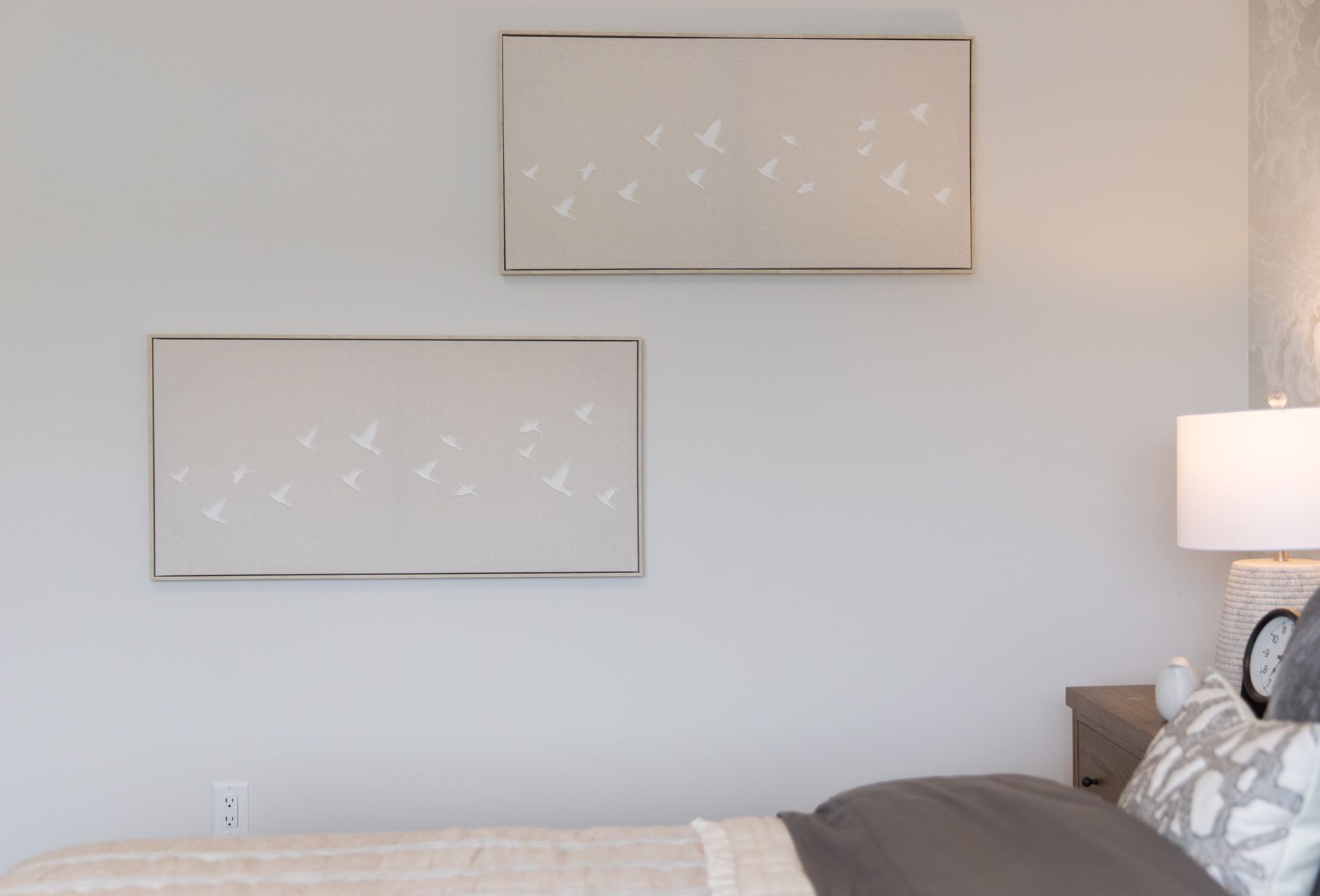 There are two paintings on the wall above the bed.