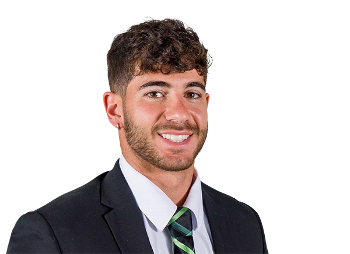 A man with a beard is wearing a white t-shirt and smiling.
