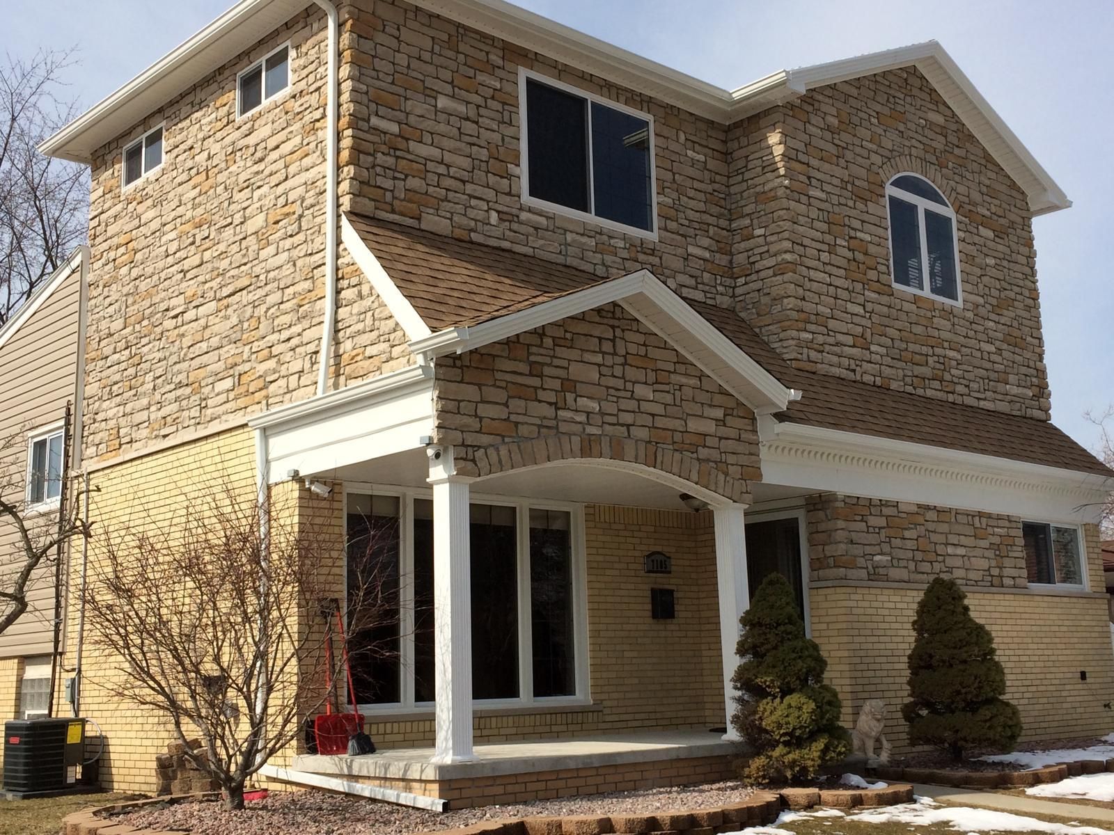 A large brick house with a porch and many windows