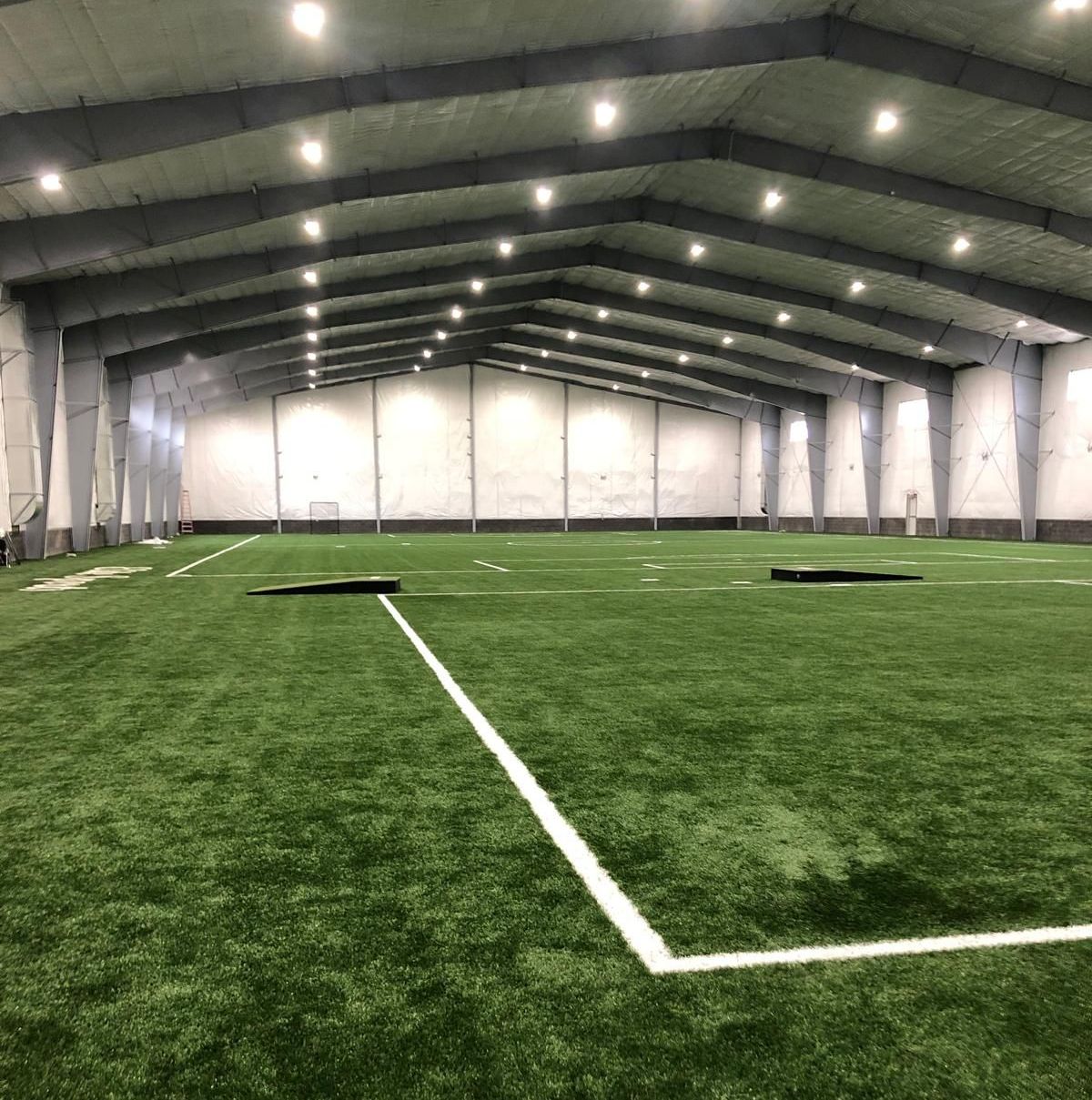 A large indoor soccer field with a white line in the middle