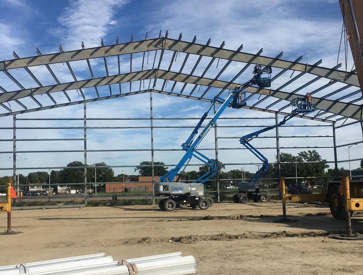 A large metal structure is being built on a construction site.