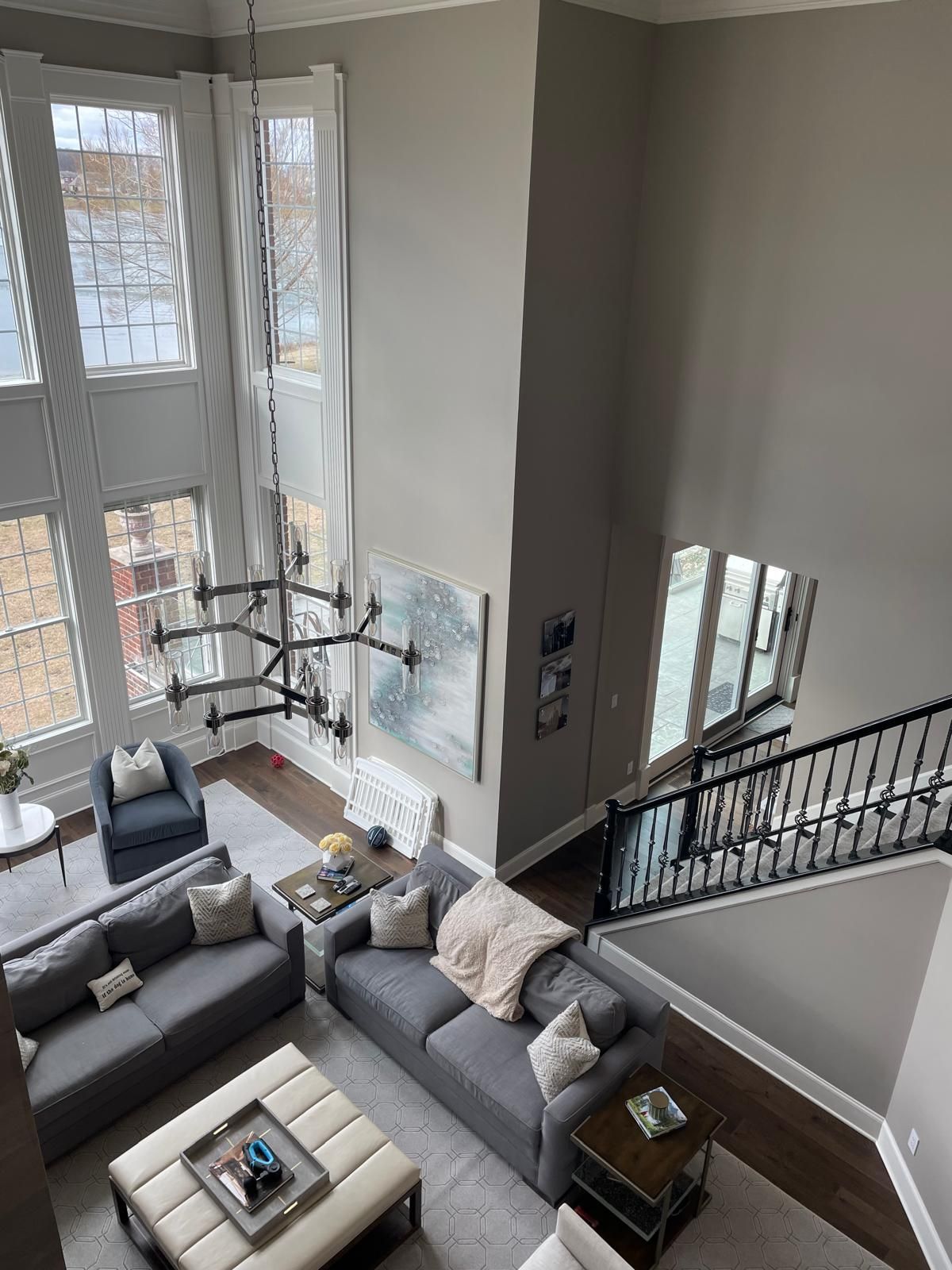 An aerial view of a living room with a couch , coffee table , chairs and stairs.