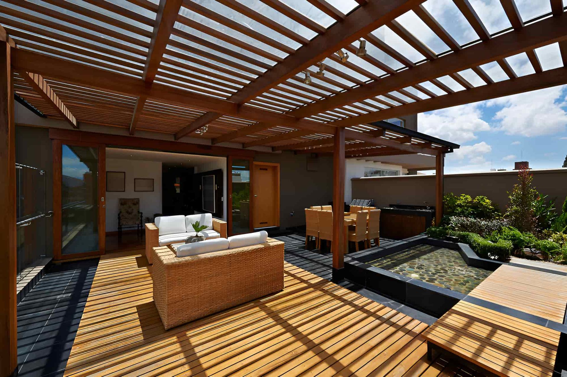 A Patio With Wooden Furniture and a Pergola — Pride Carpentry & Maintenance In Berkeley Vale, NSW