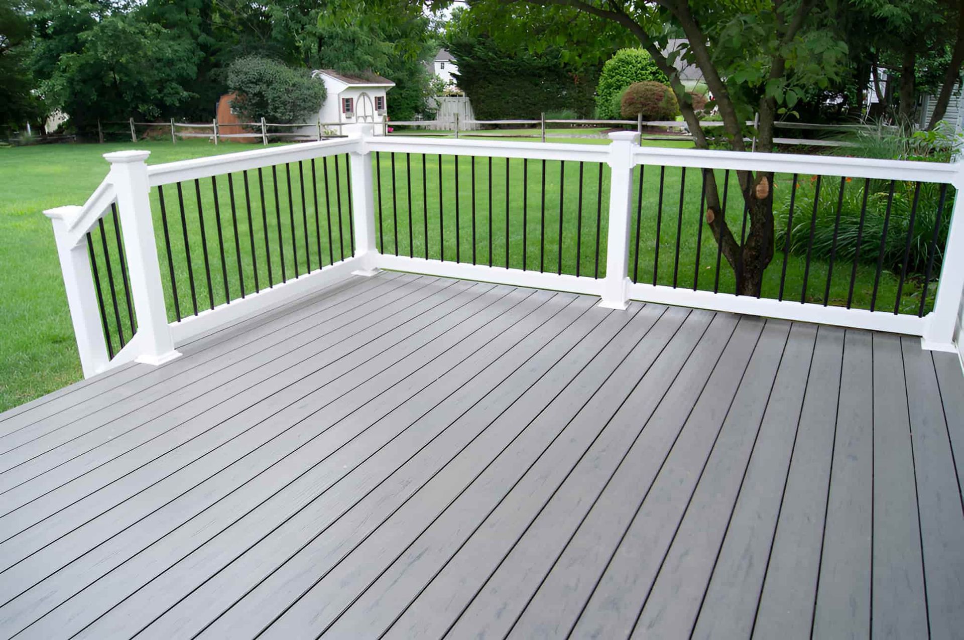 A Wooden Deck With a Combination of White and Black Railings — Pride Carpentry & Maintenance In Berkeley Vale, NSW