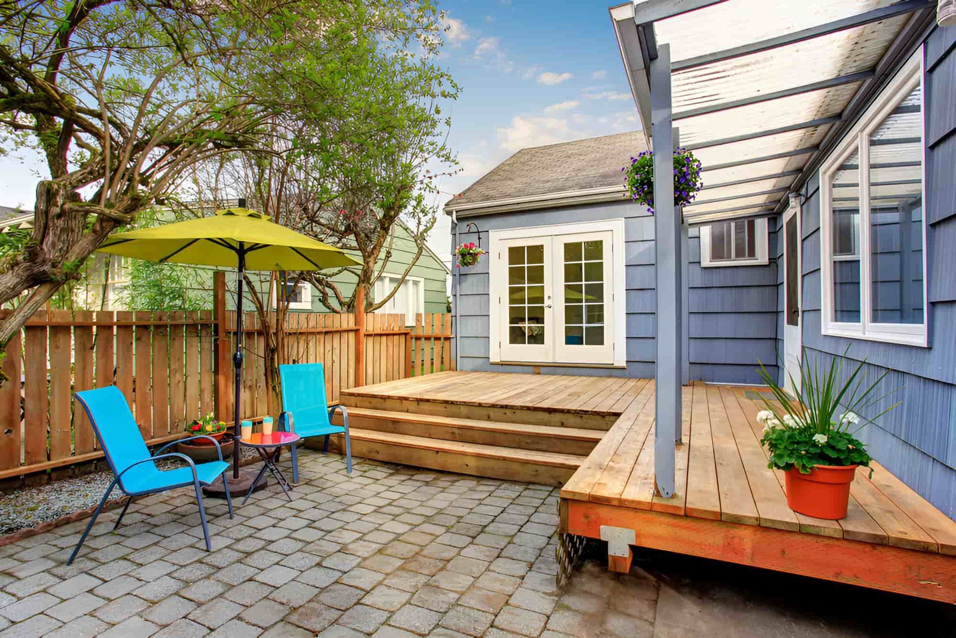 A Patio Area Next to a Blue House — Pride Carpentry & Maintenance In Berkeley Vale, NSW