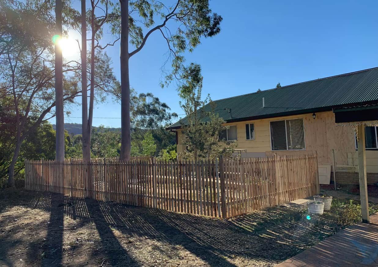 A House With a Wooden Fence and Trees — Pride Carpentry & Maintenance In Berkeley Vale, NSW