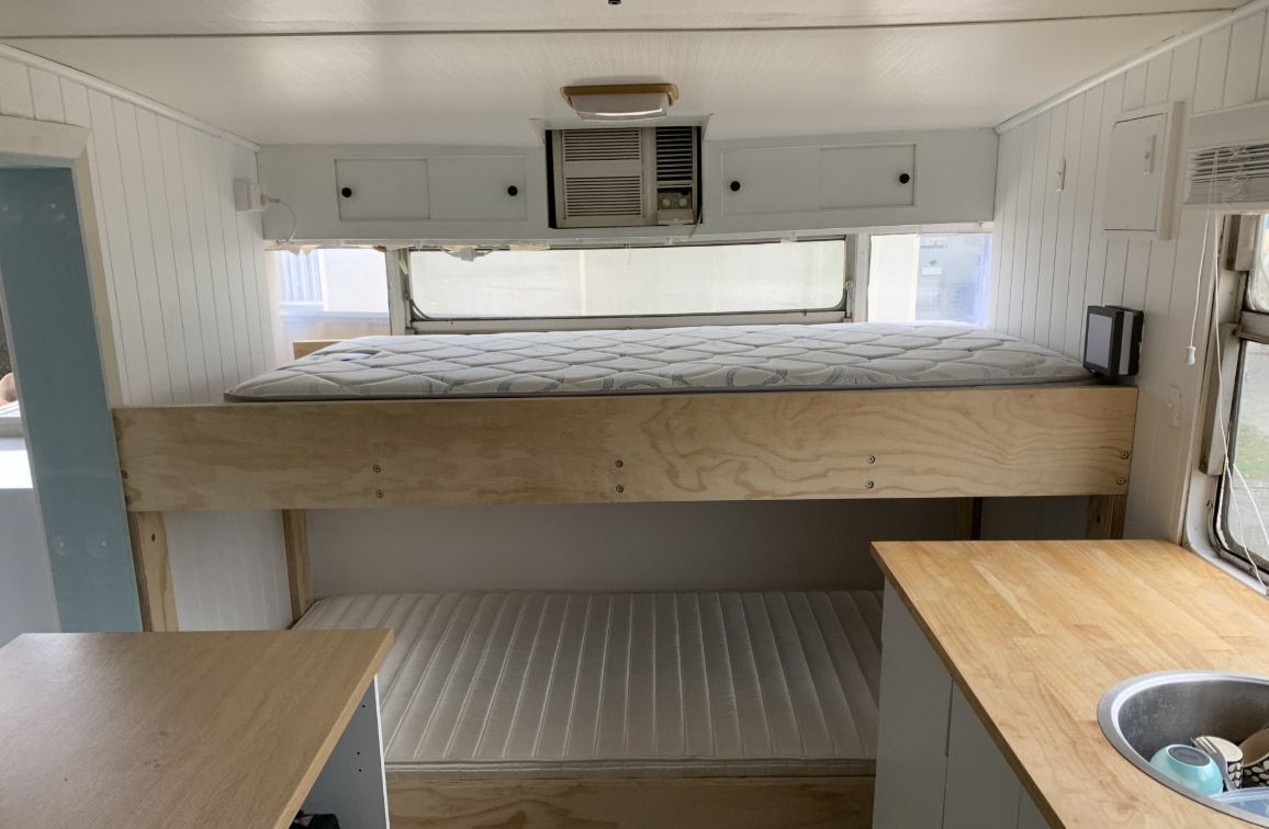 A Small Bedroom Featuring a Bed and a Sink — Pride Carpentry & Maintenance In Berkeley Vale, NSW