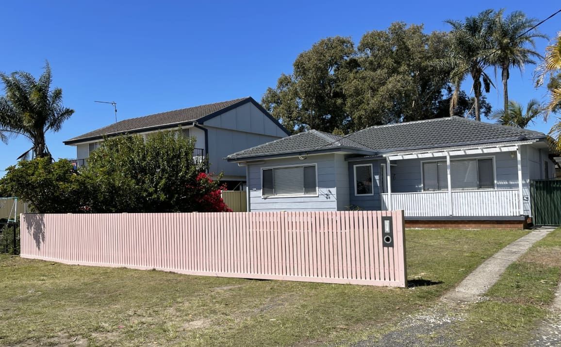A House Next to a Pink Fence — Pride Carpentry & Maintenance In Berkeley Vale, NSW