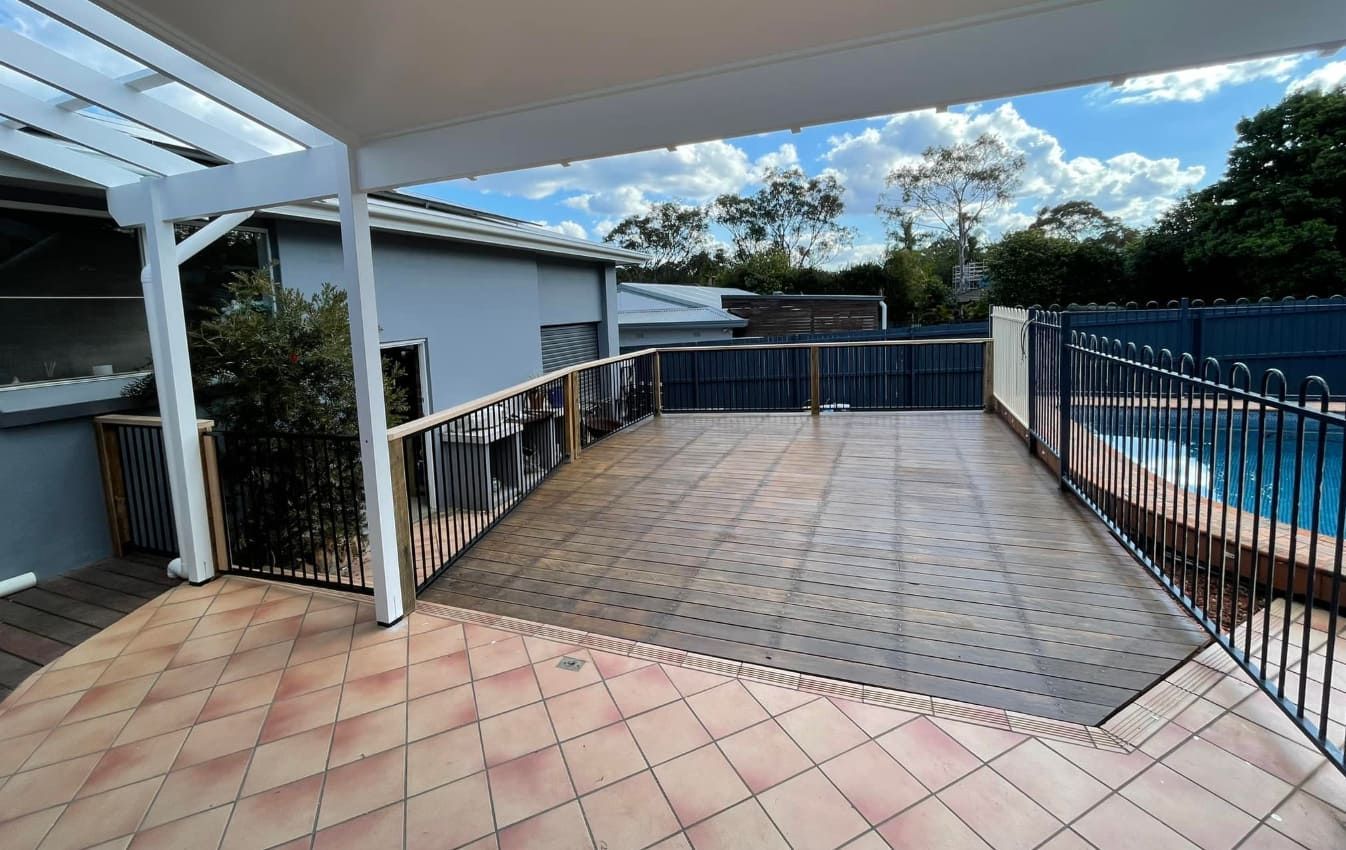 A Deck With a Pool Enclosed by a Fence — Pride Carpentry & Maintenance In Central Coast, NSW