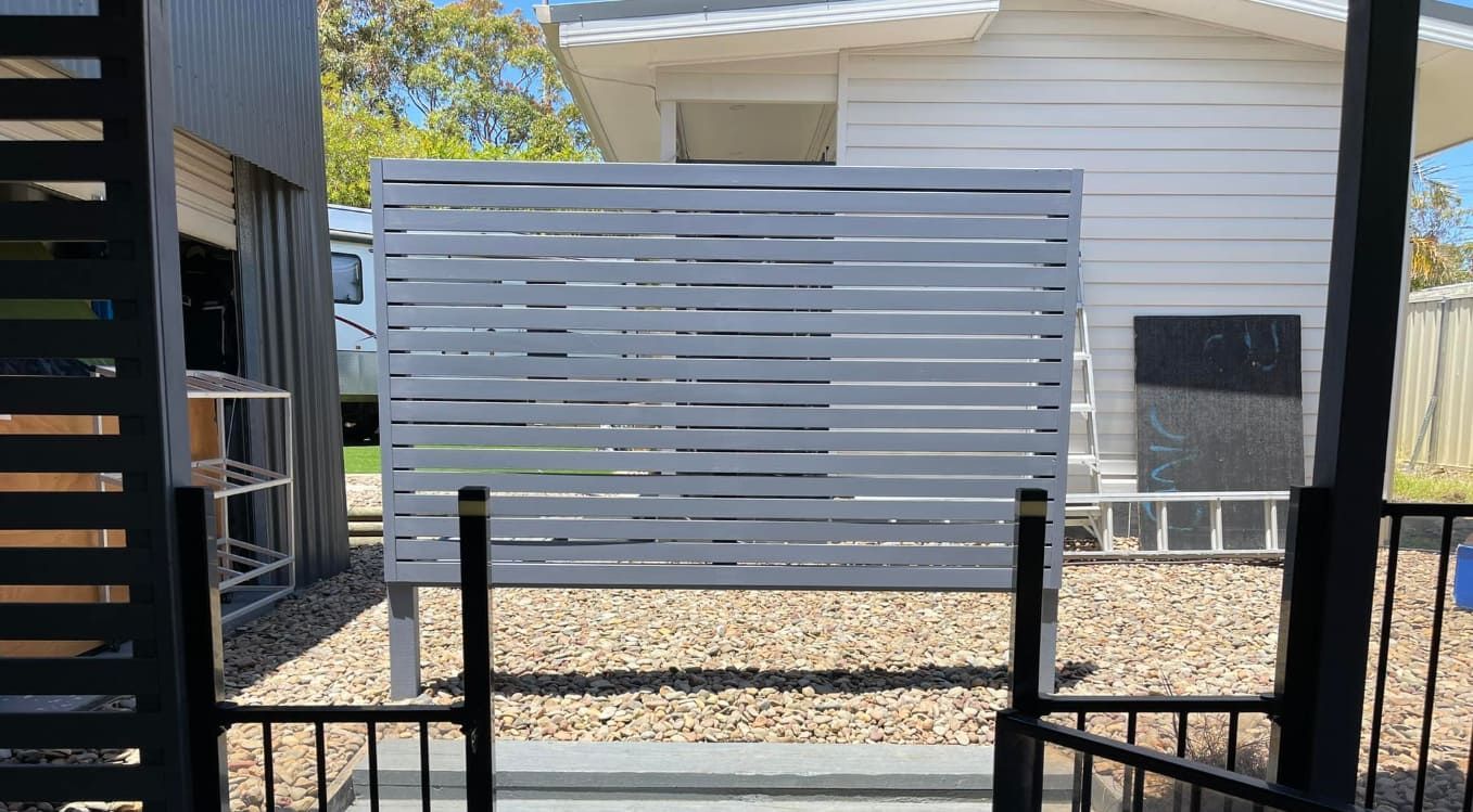 A White Privacy Screen in the Middle — Pride Carpentry & Maintenance In Lake Macquarie, NSW
