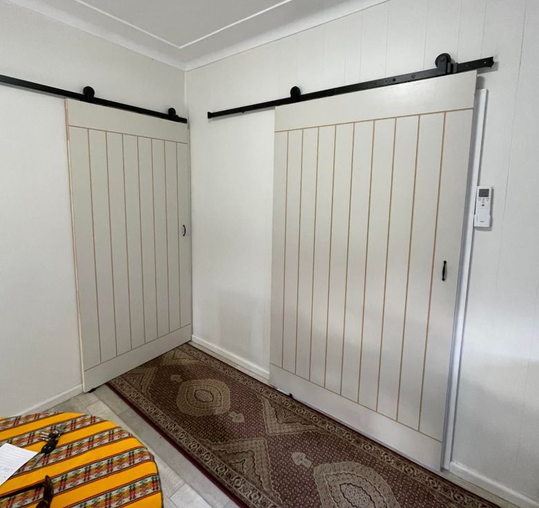 Two Sliding Doors and a Rug Below — Pride Carpentry & Maintenance In Berkeley Vale, NSW