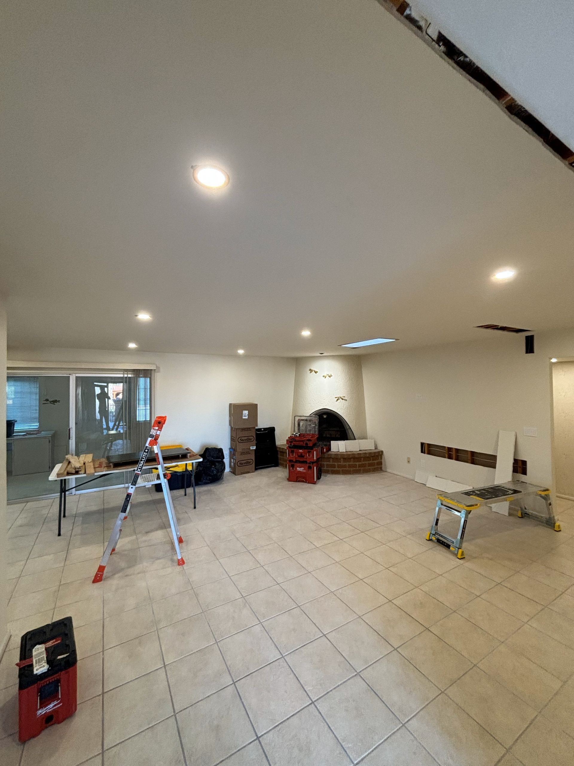 Person using a squeegee to clean a window, streaks of water and bubbles visible.