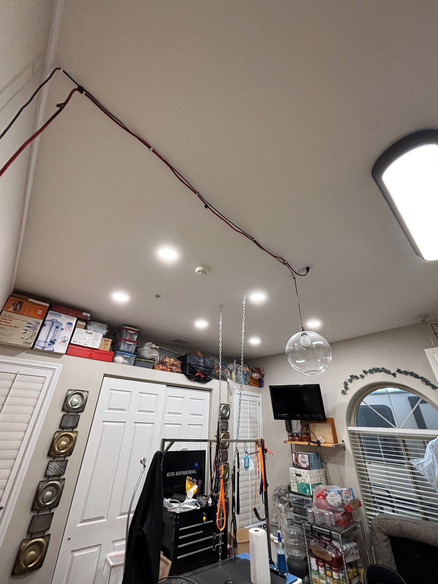 Window being cleaned with a long-handled brush, water spraying across the glass.