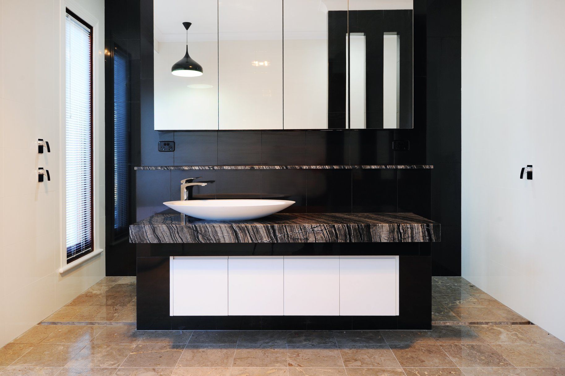 Modern Bathroom With Black and White Vanity, Marble Countertop, and Vessel Sink.