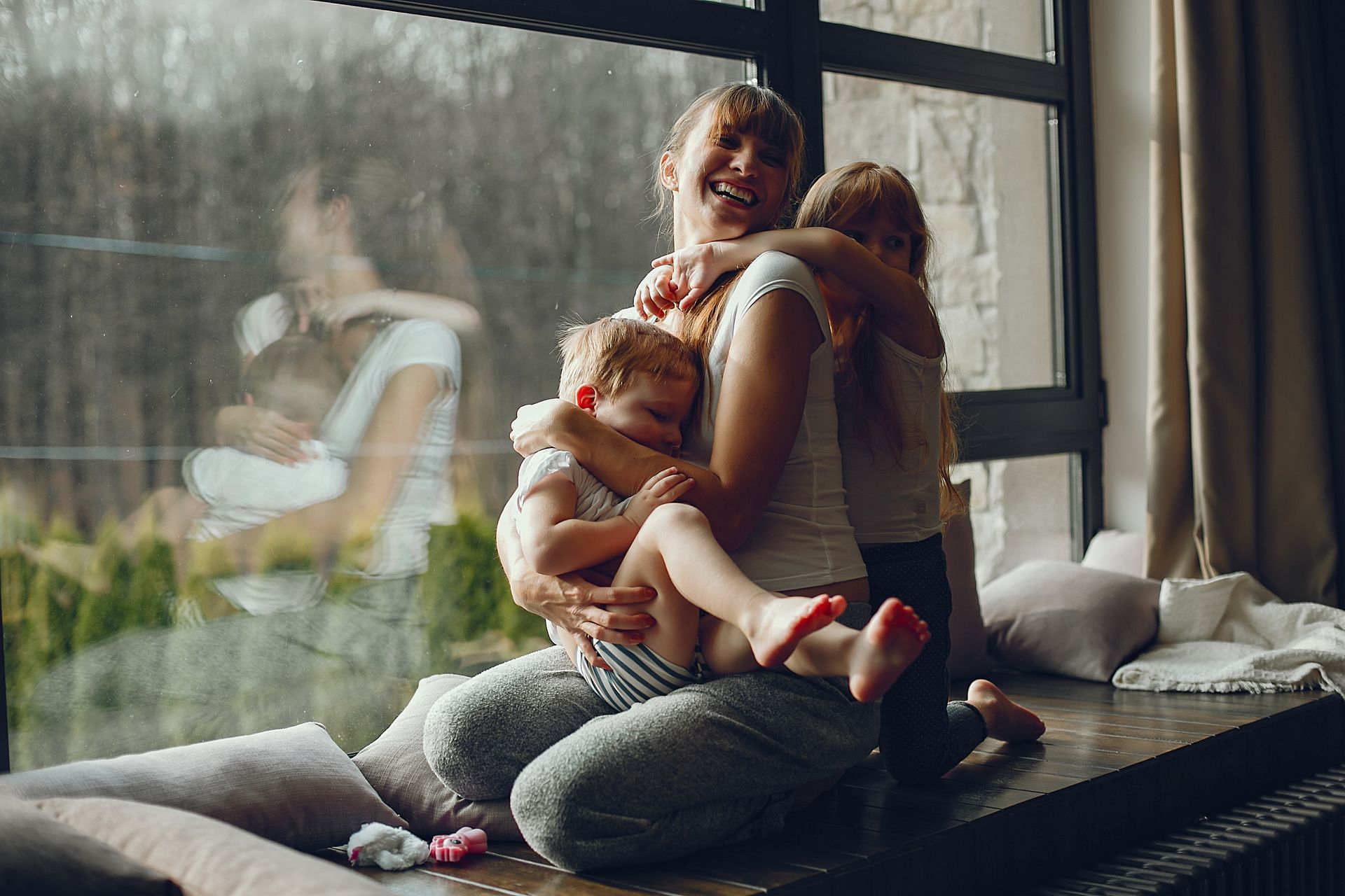 A woman is hugging a man while holding a glass of wine.
