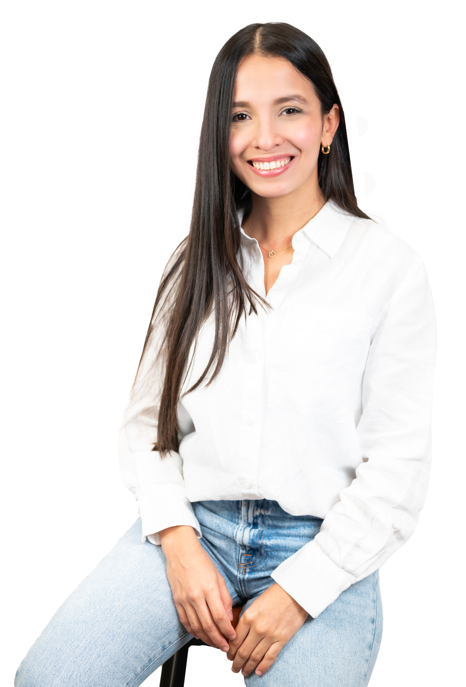 A woman is sitting on a stool wearing a white shirt and jeans.