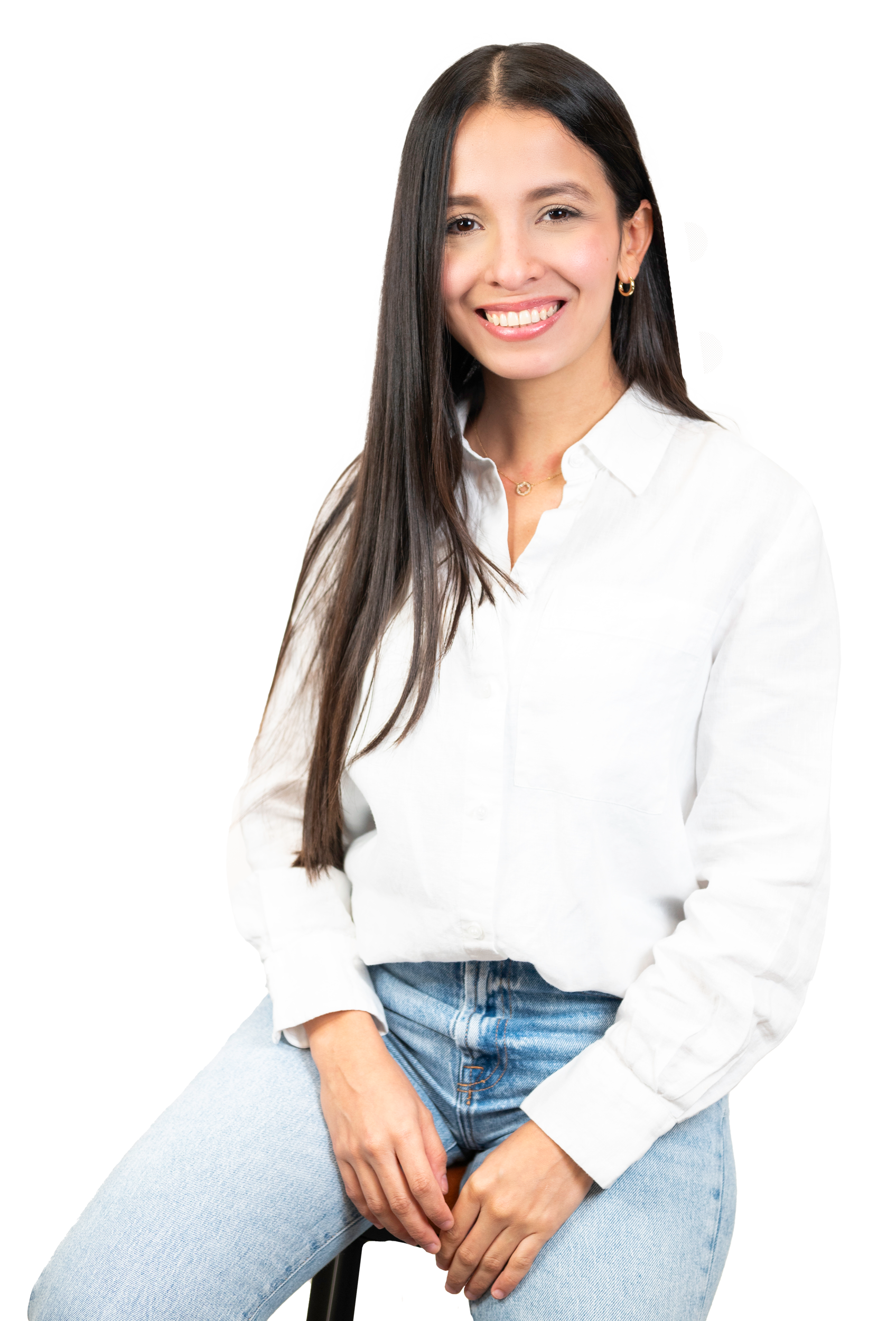 A woman is sitting on a stool wearing a white shirt and jeans.