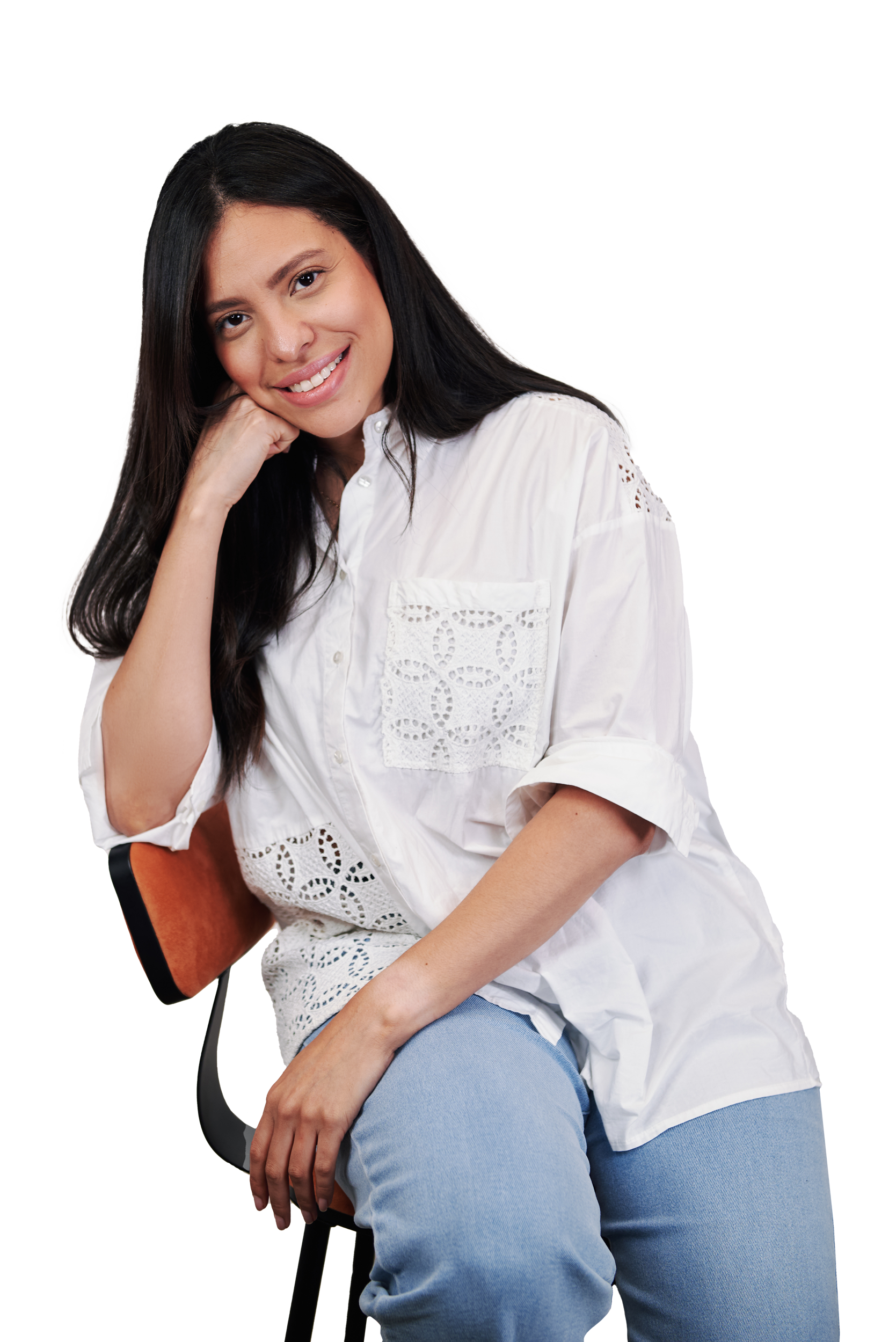 A woman in a white shirt and blue jeans is sitting on a chair.