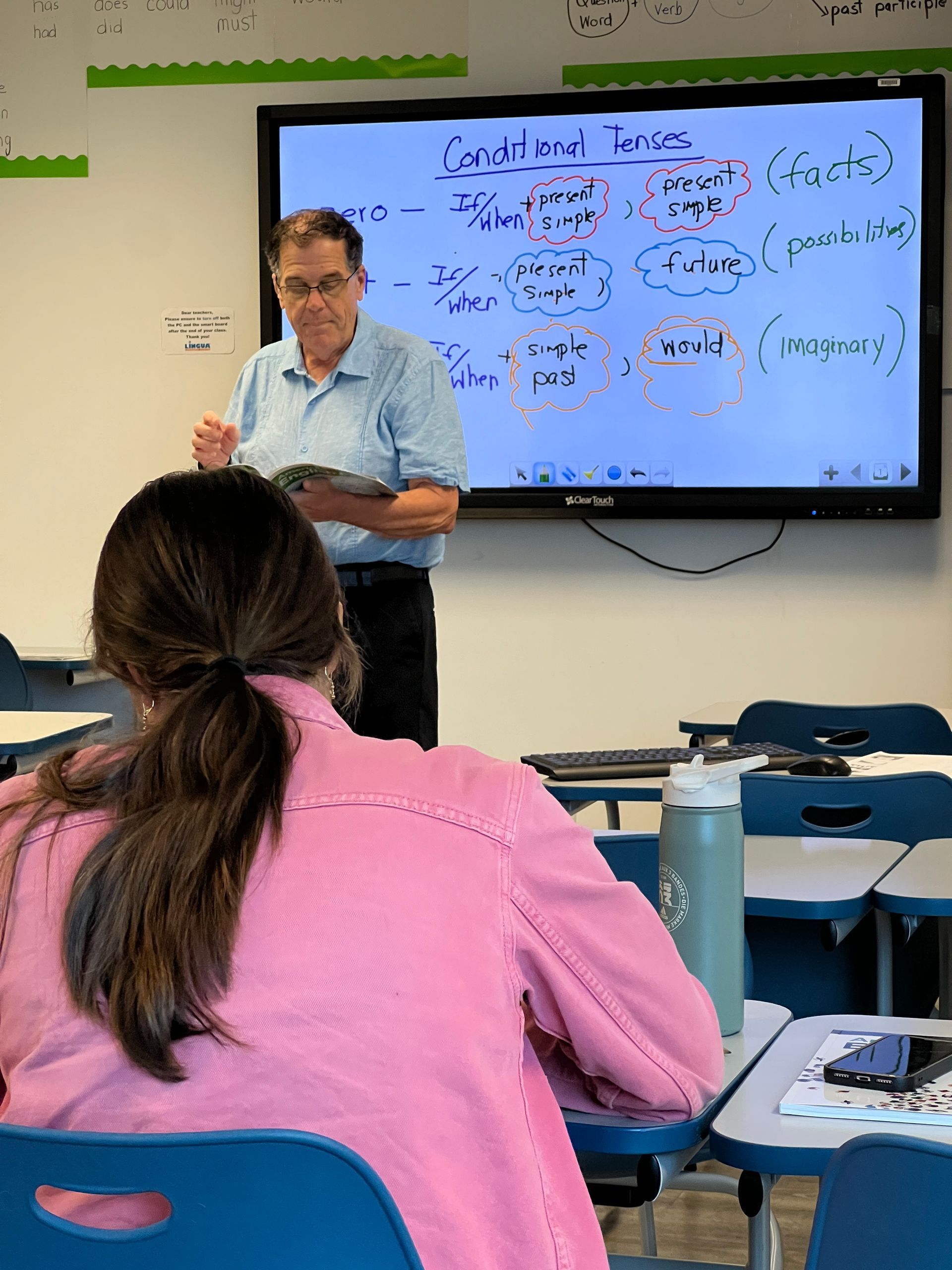 English Teacher at a classroom screen. Lingua Language Center. Correct spelling.