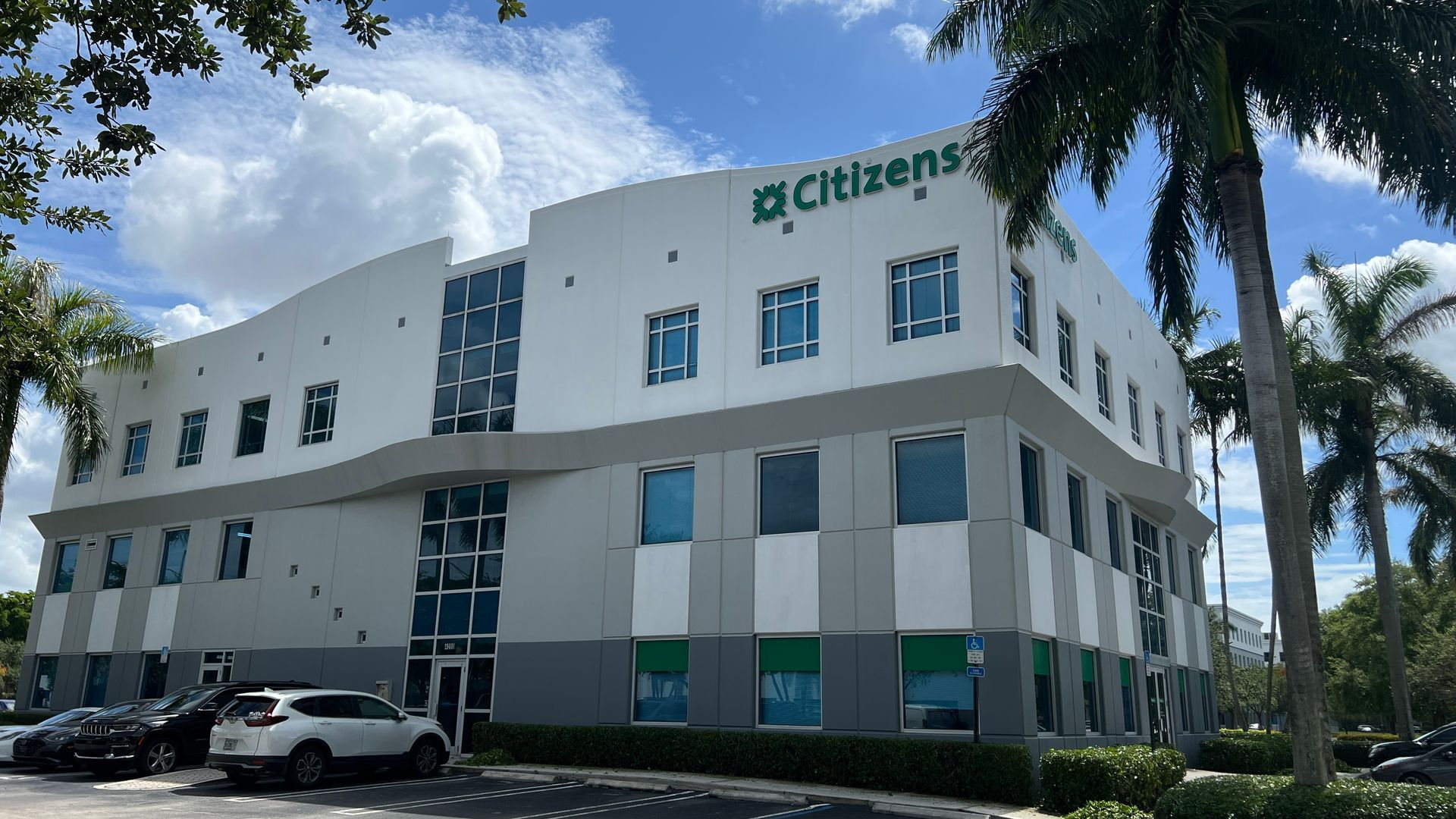 A large white building with a palm tree in front of it.