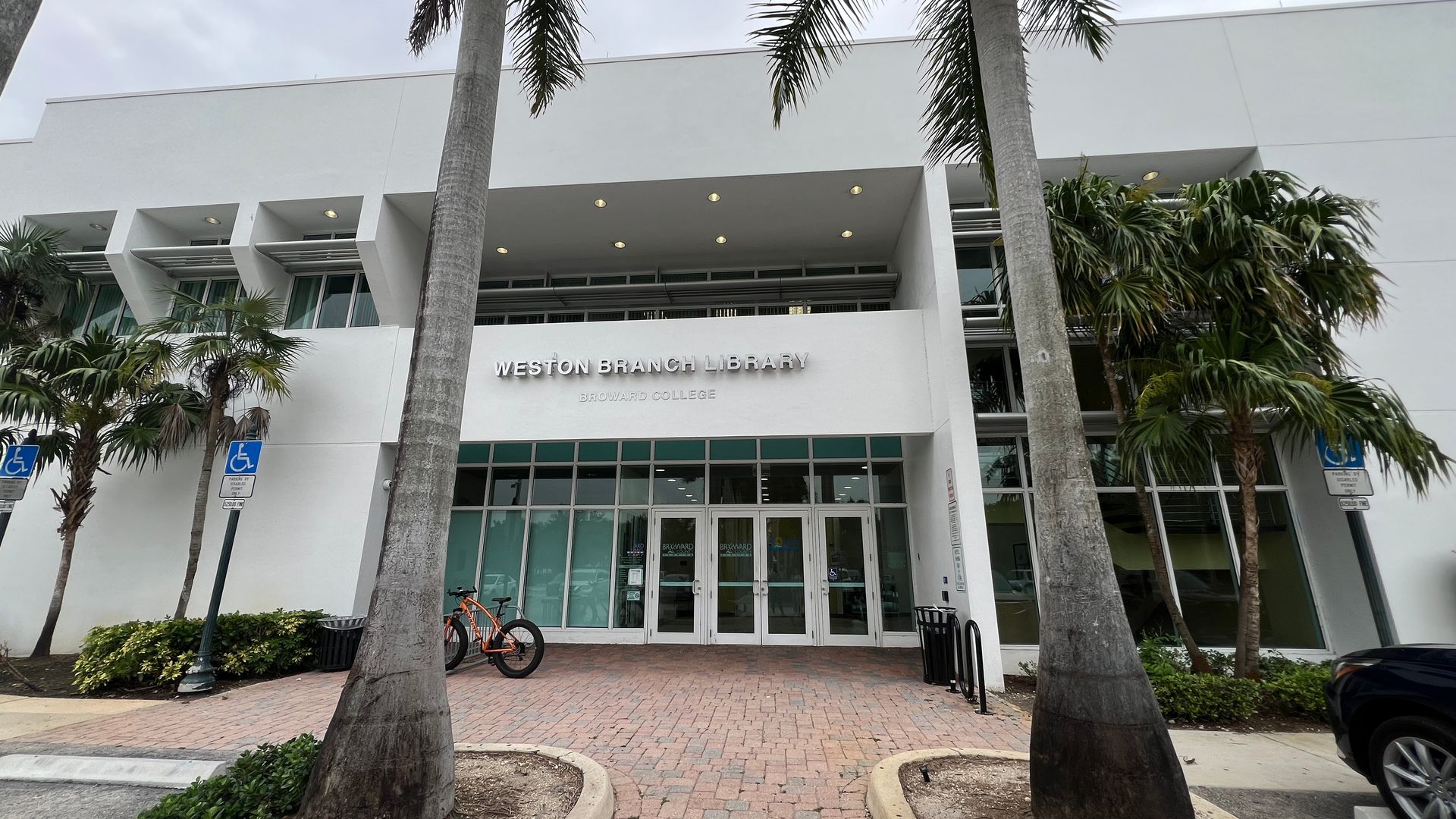 A white building with palm trees in front of it