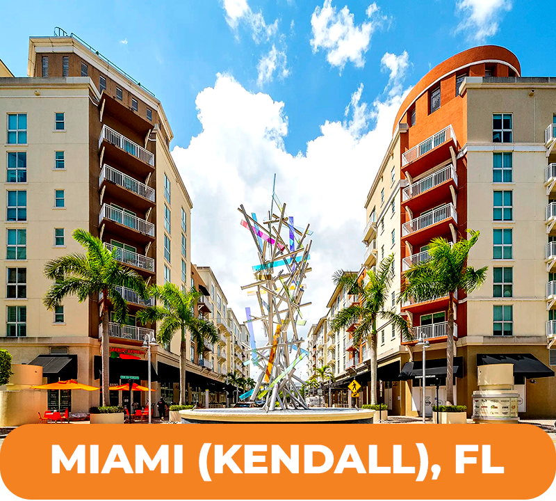 Street view in Kendall, Miami, with tall buildings, palm trees, sculpture, and text