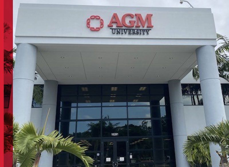 AGM University building entrance with white columns and glass doors