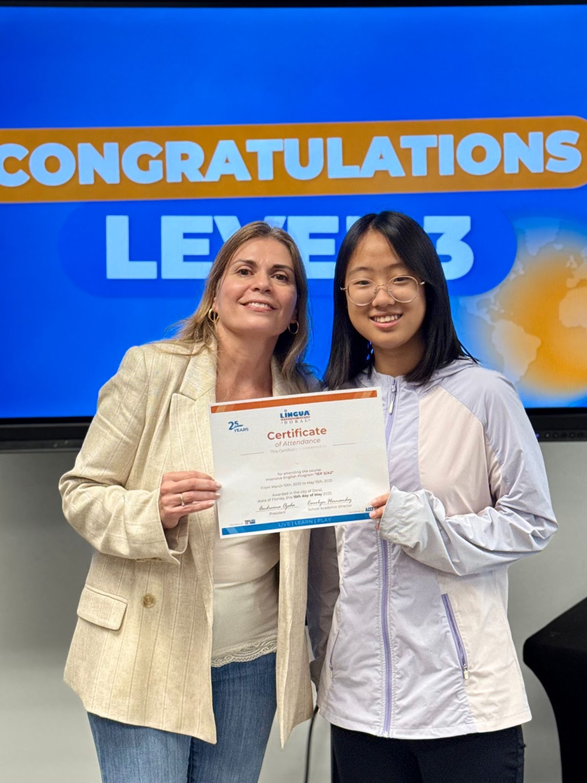 A student and teacher posing with certificate of completion of the TOEFL exam in English classes