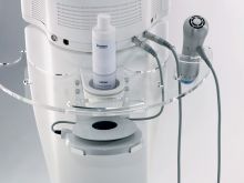 A white machine with a bottle of lotion on top of it.