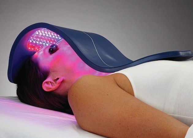 A woman is laying on a bed with a hat on her head