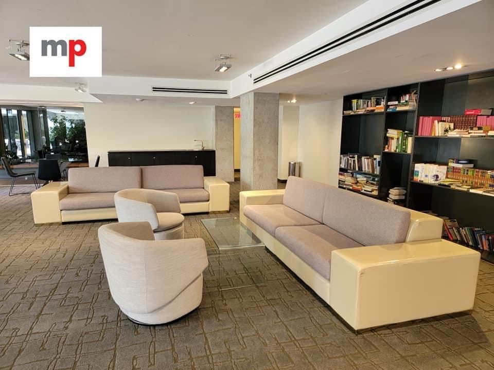 Un salon avec un canapé et des chaises et un logo pour mp