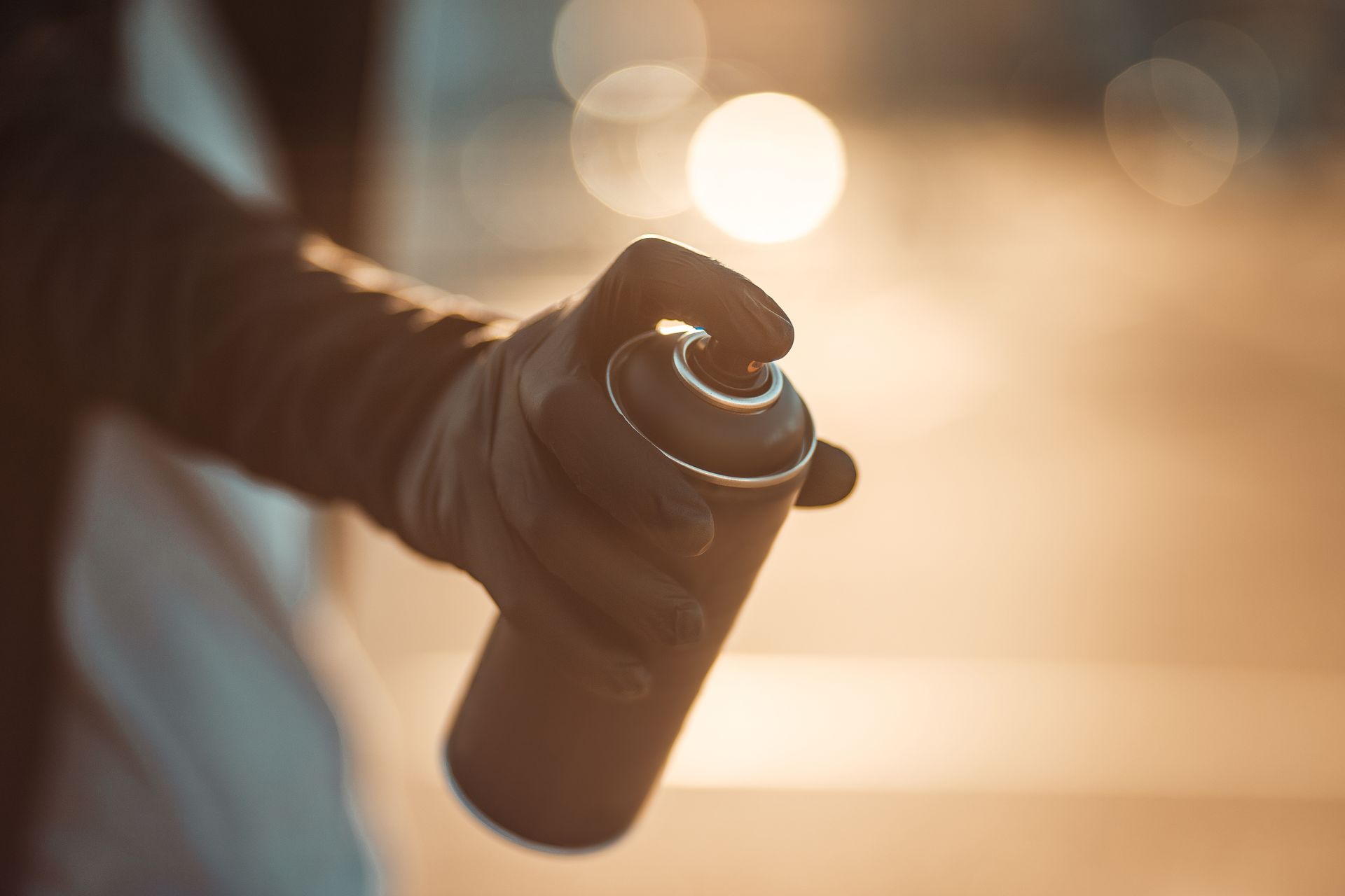 Une personne tient une bombe aérosol dans sa main.