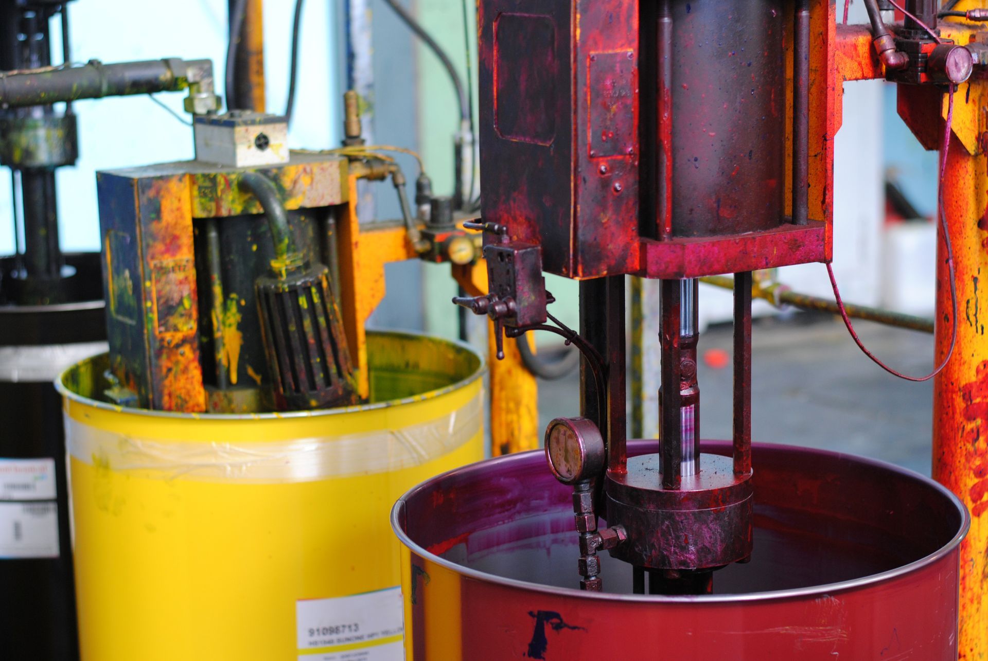 Une machine mélange un liquide violet dans un baril jaune.