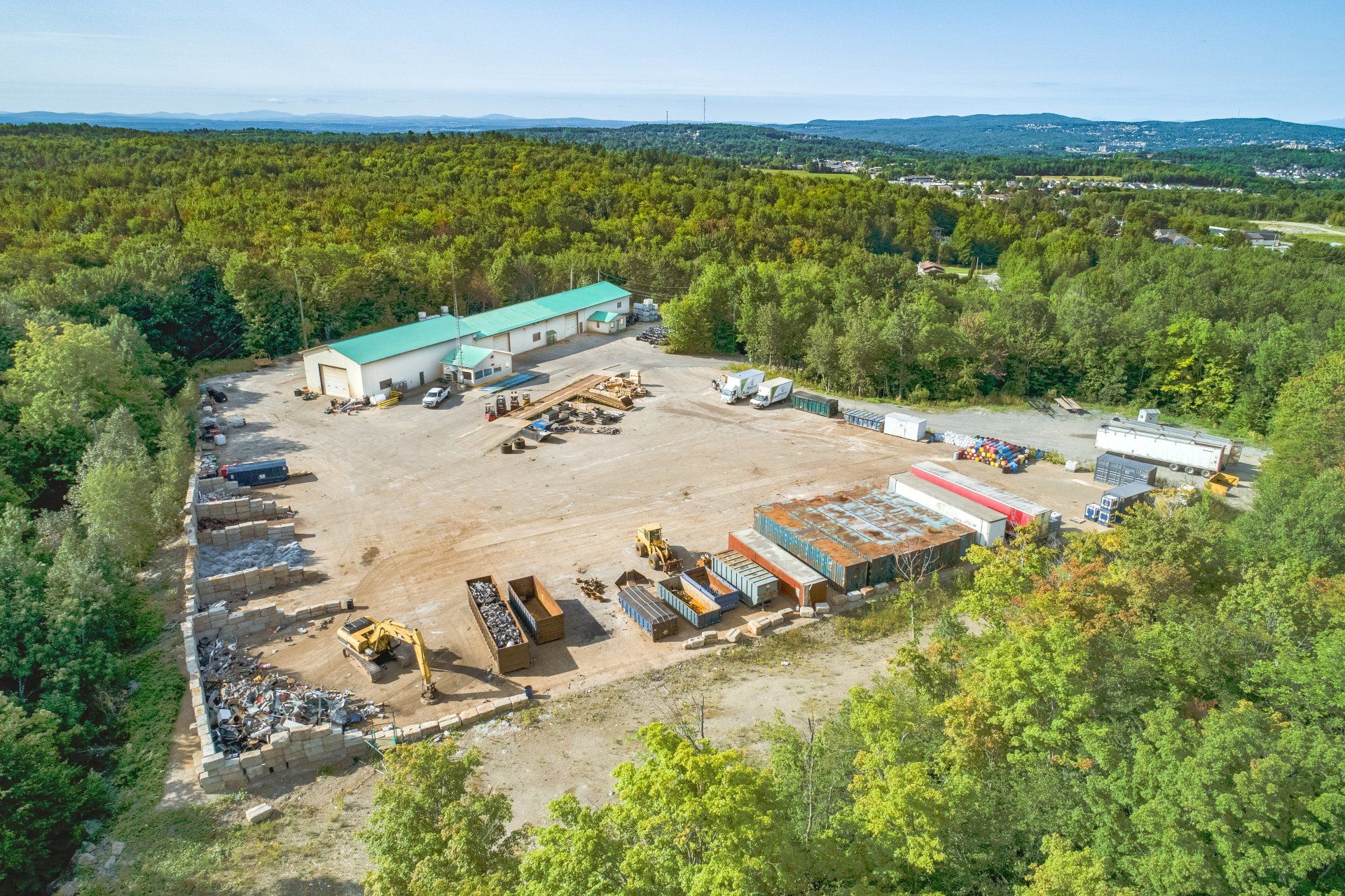 Une vue aérienne d'un grand entrepôt entouré d'arbres.