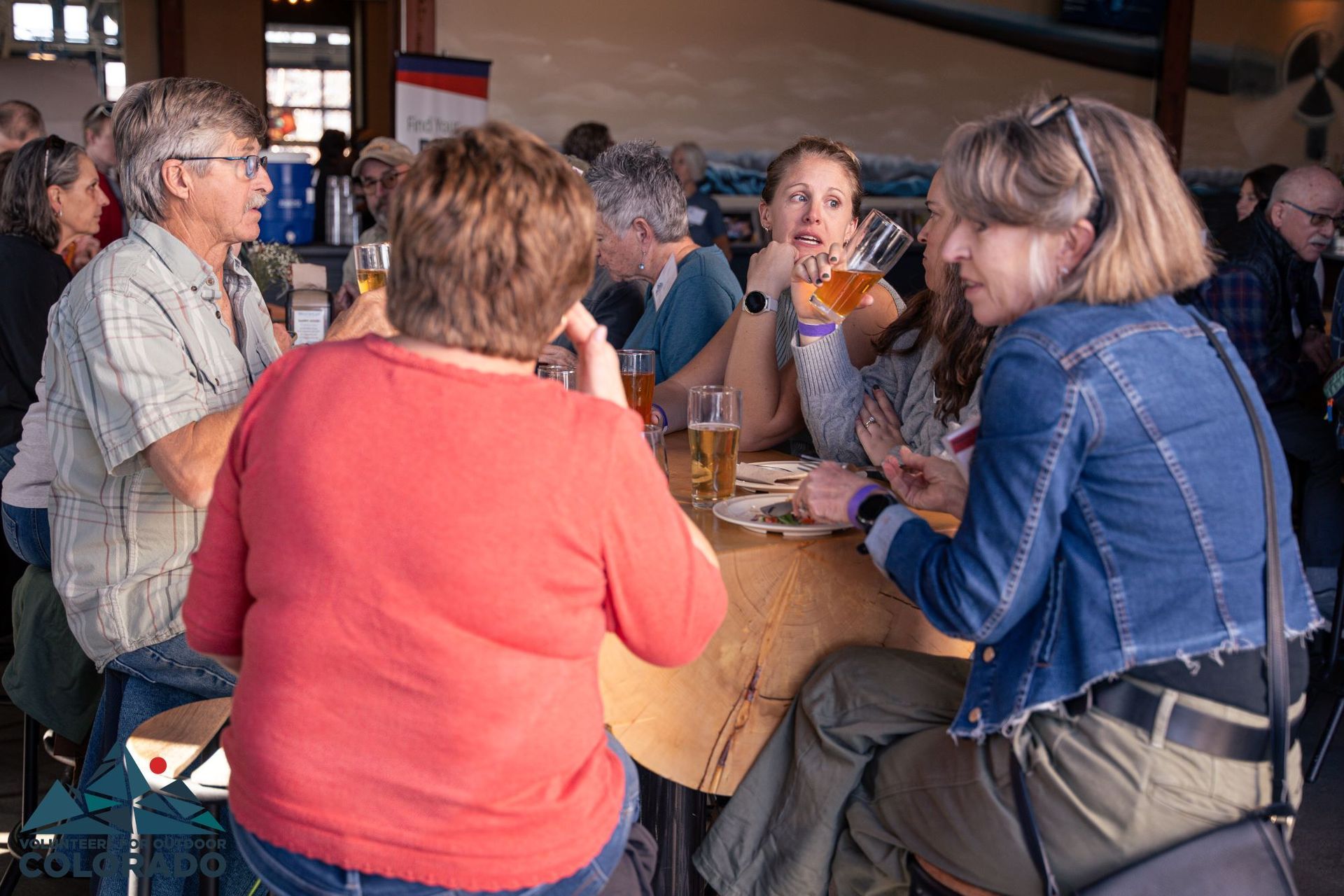 Volunteers gathered around a table enjoying brews and lunch